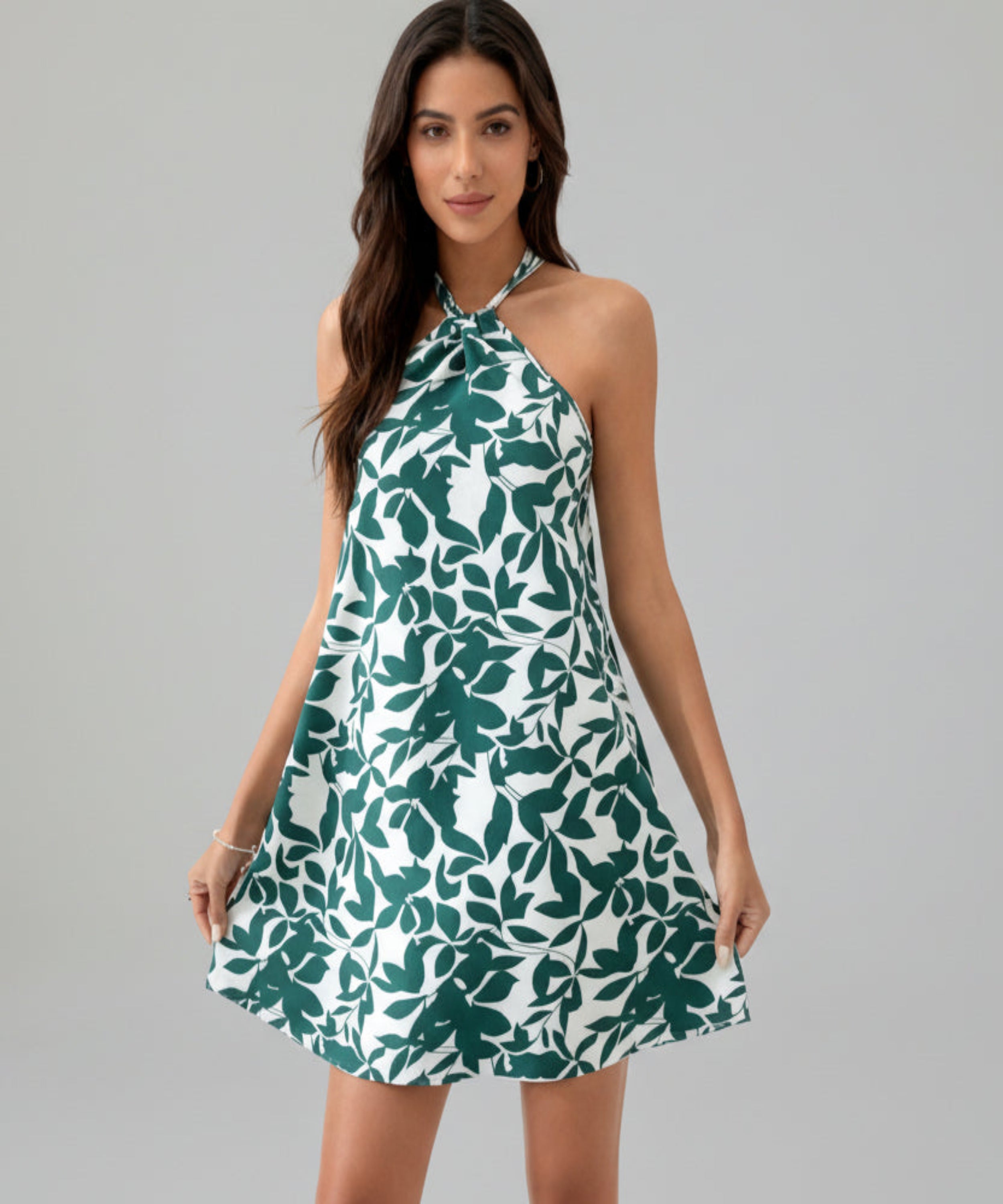 Woman wearing a green and white floral dress on a white background