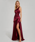 Woman wearing a burgundy one-shoulder dress with a slit on a white background