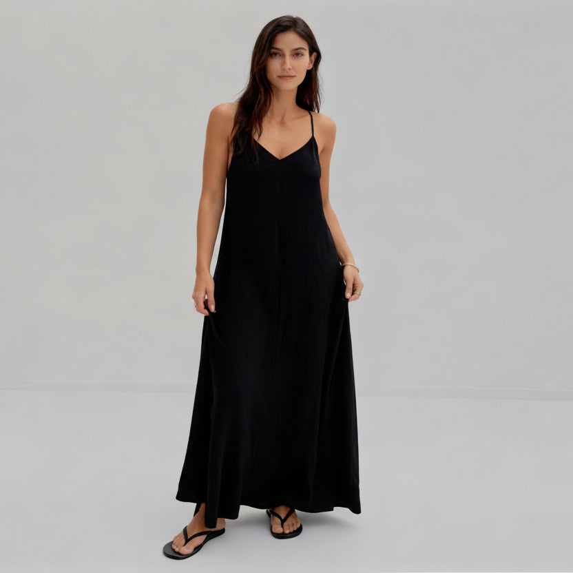 Woman wearing a black slip dress on a white background