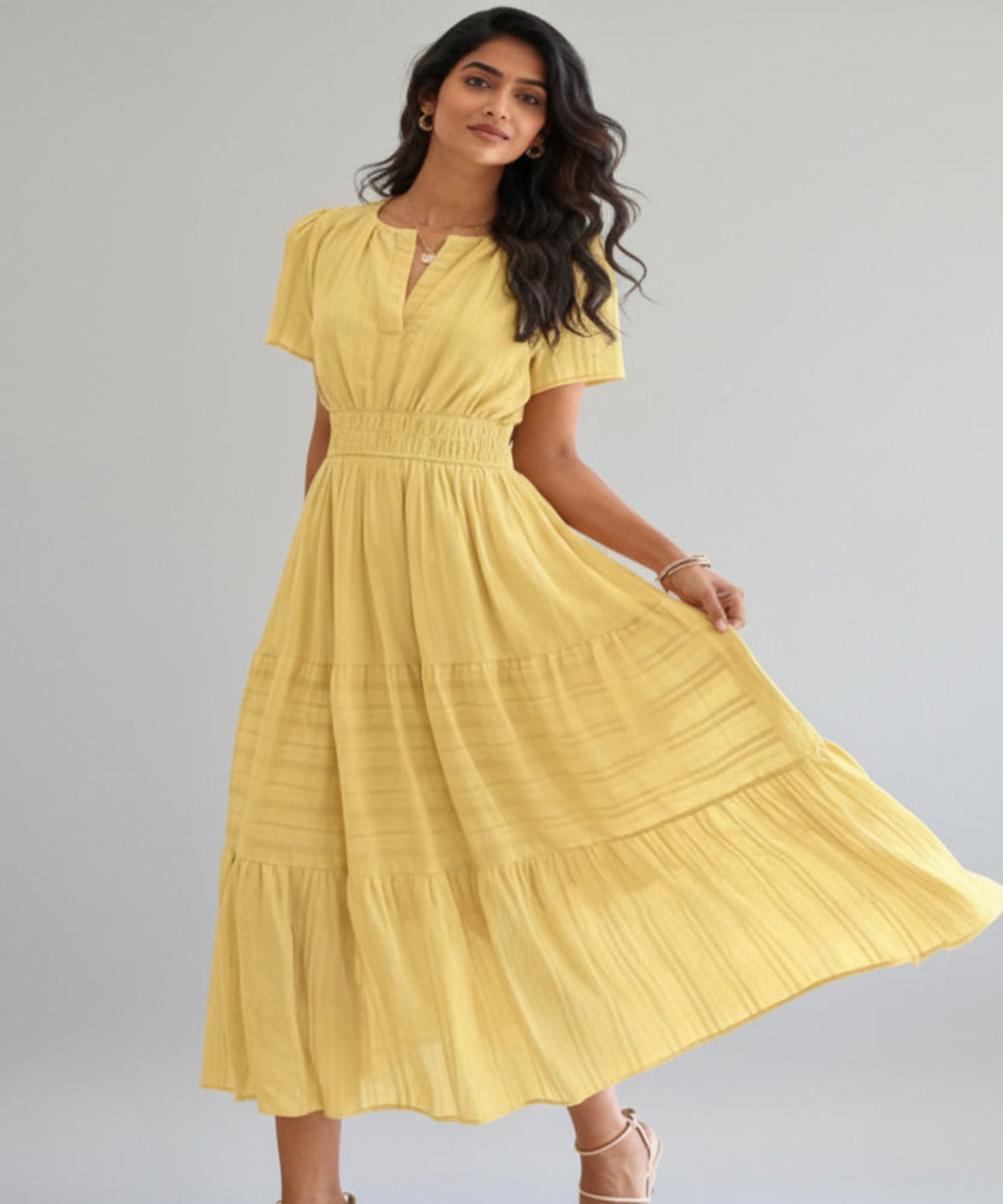 Woman wearing a yellow dress on a white background