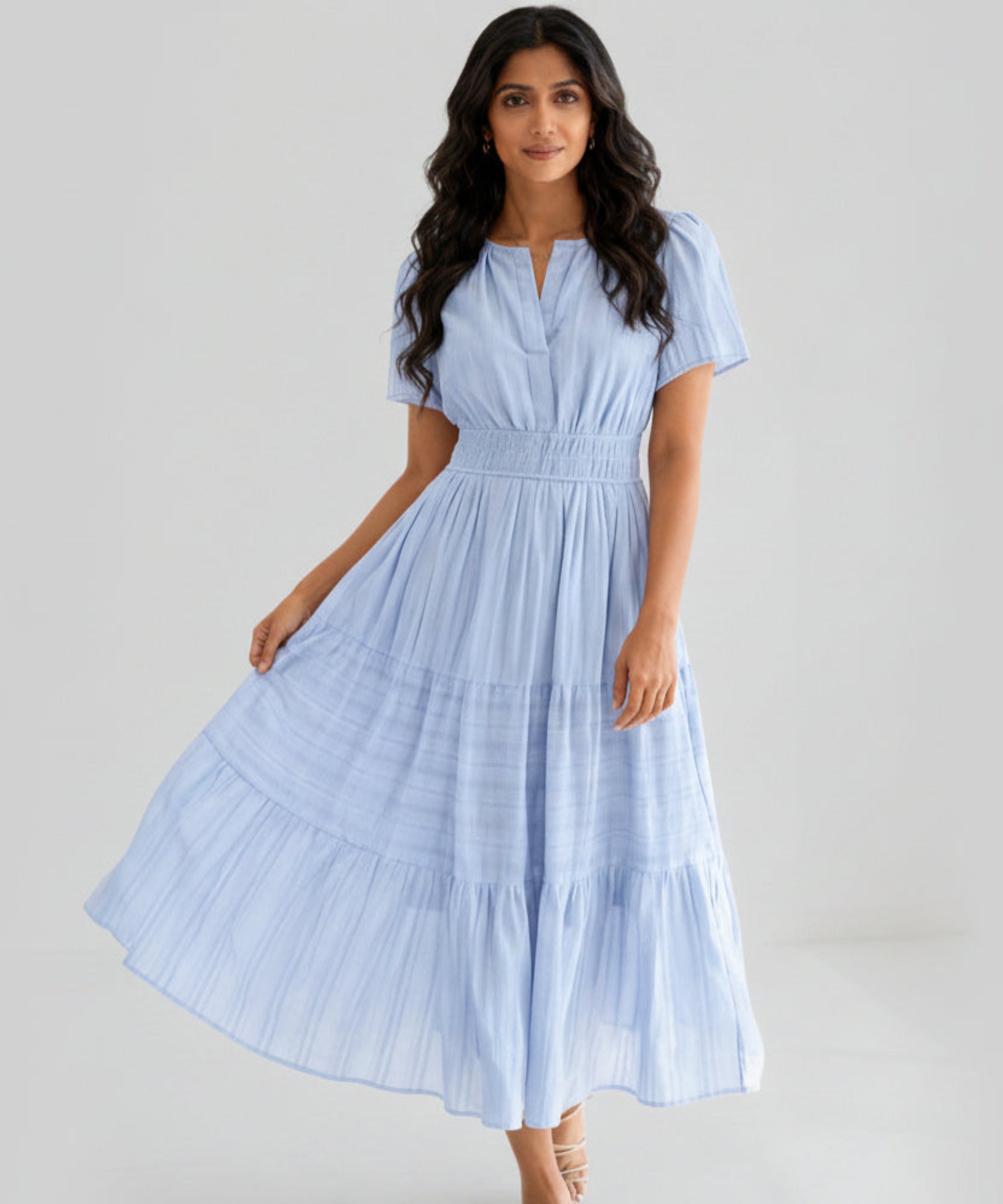 Woman wearing a light blue dress on a white background