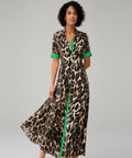 Woman wearing a leopard print dress with green accents on a white background
