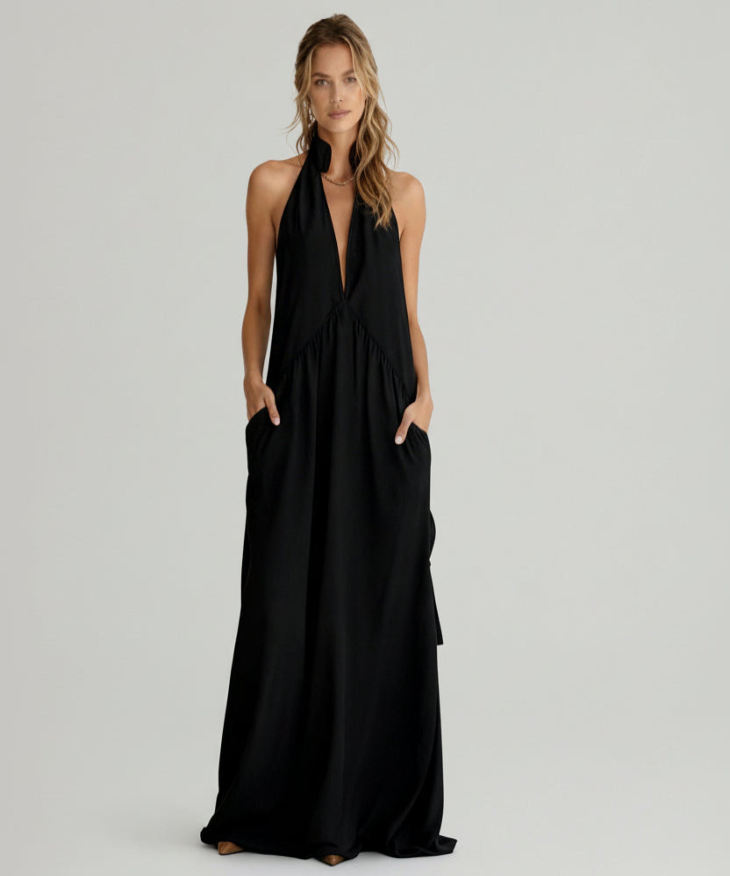 Woman wearing a black halter neck dress on a white background