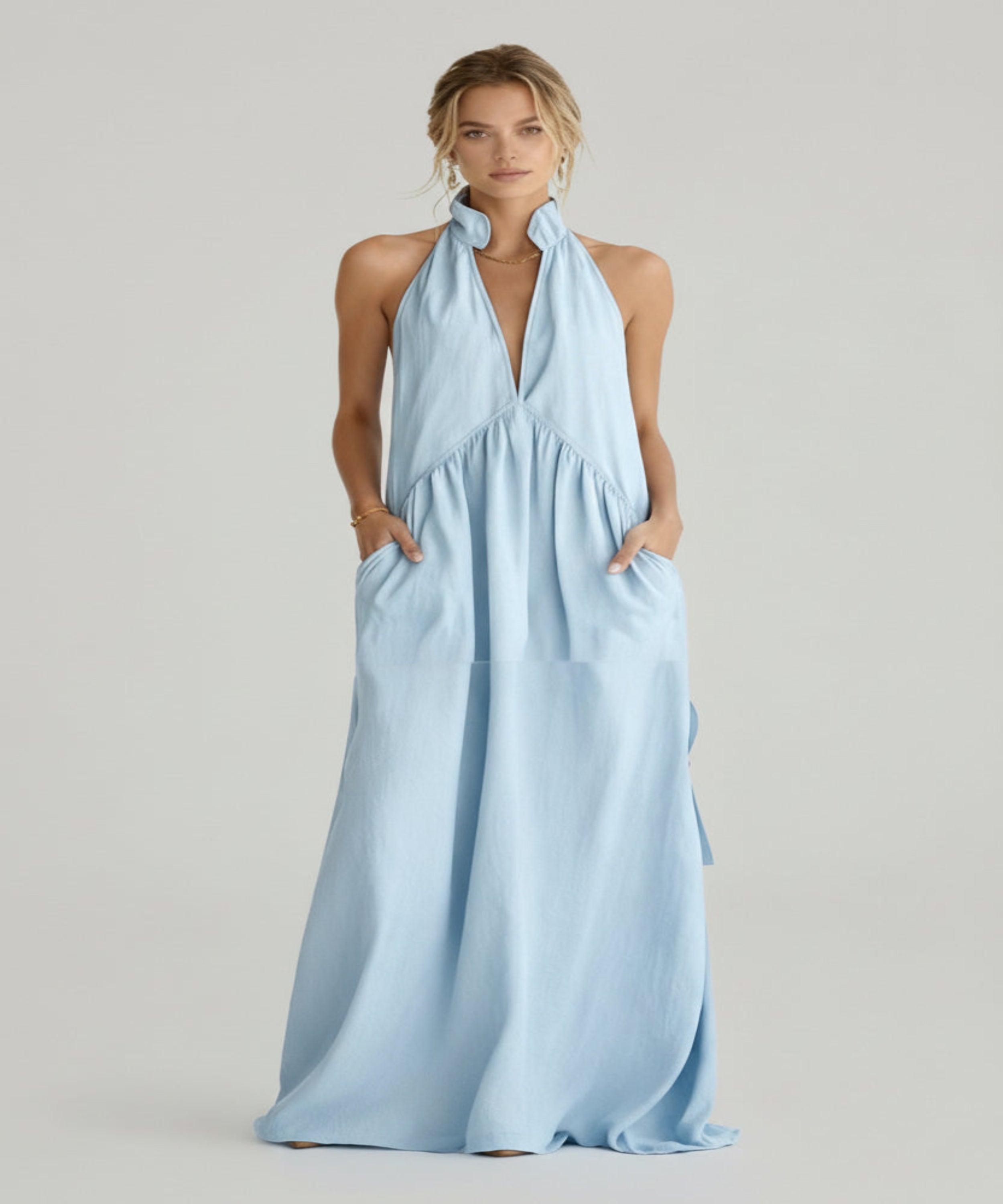 Woman wearing a light blue halter neck dress on a white background