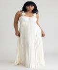 Woman wearing a white dress with floral straps on a white background