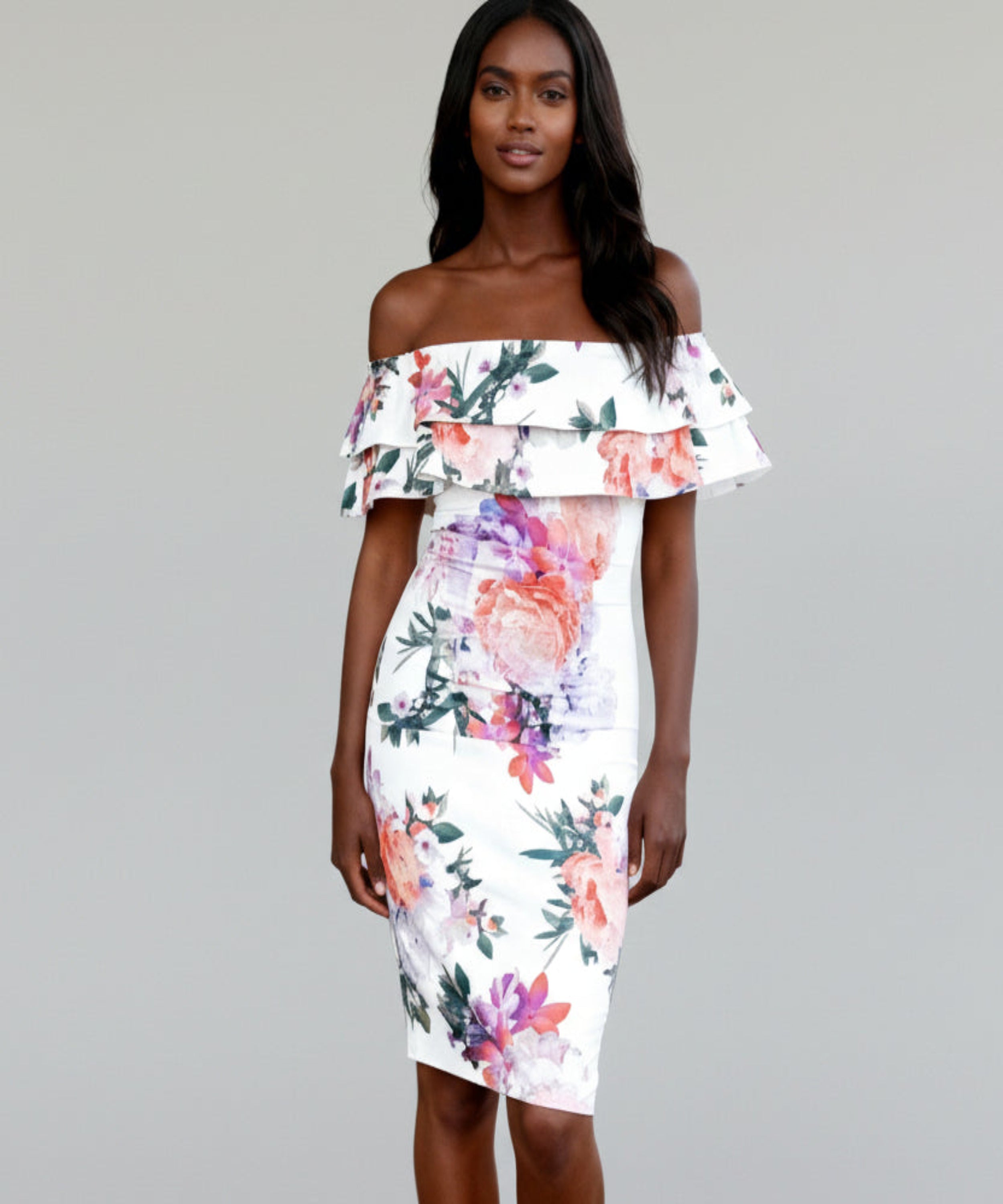 Woman wearing a floral off-shoulder dress on a white background