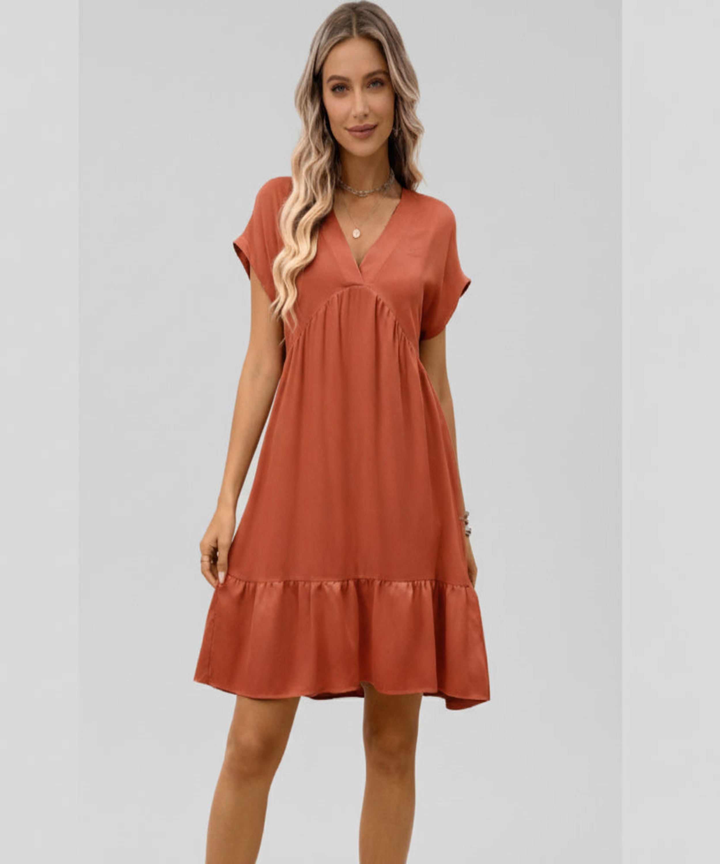 Woman wearing a rust-colored dress on a white background