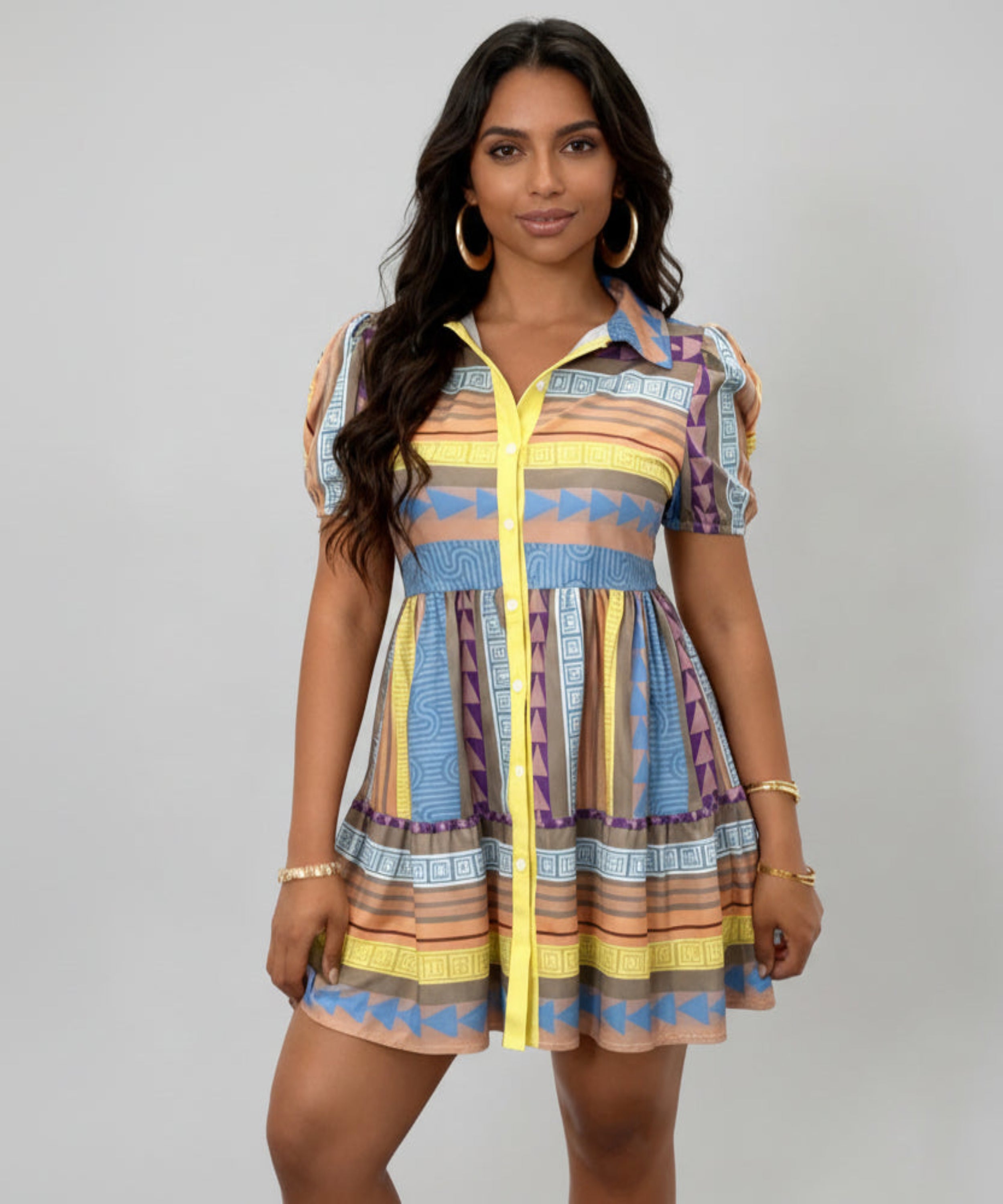 Woman wearing a colorful patterned dress with a yellow zipper on a white background