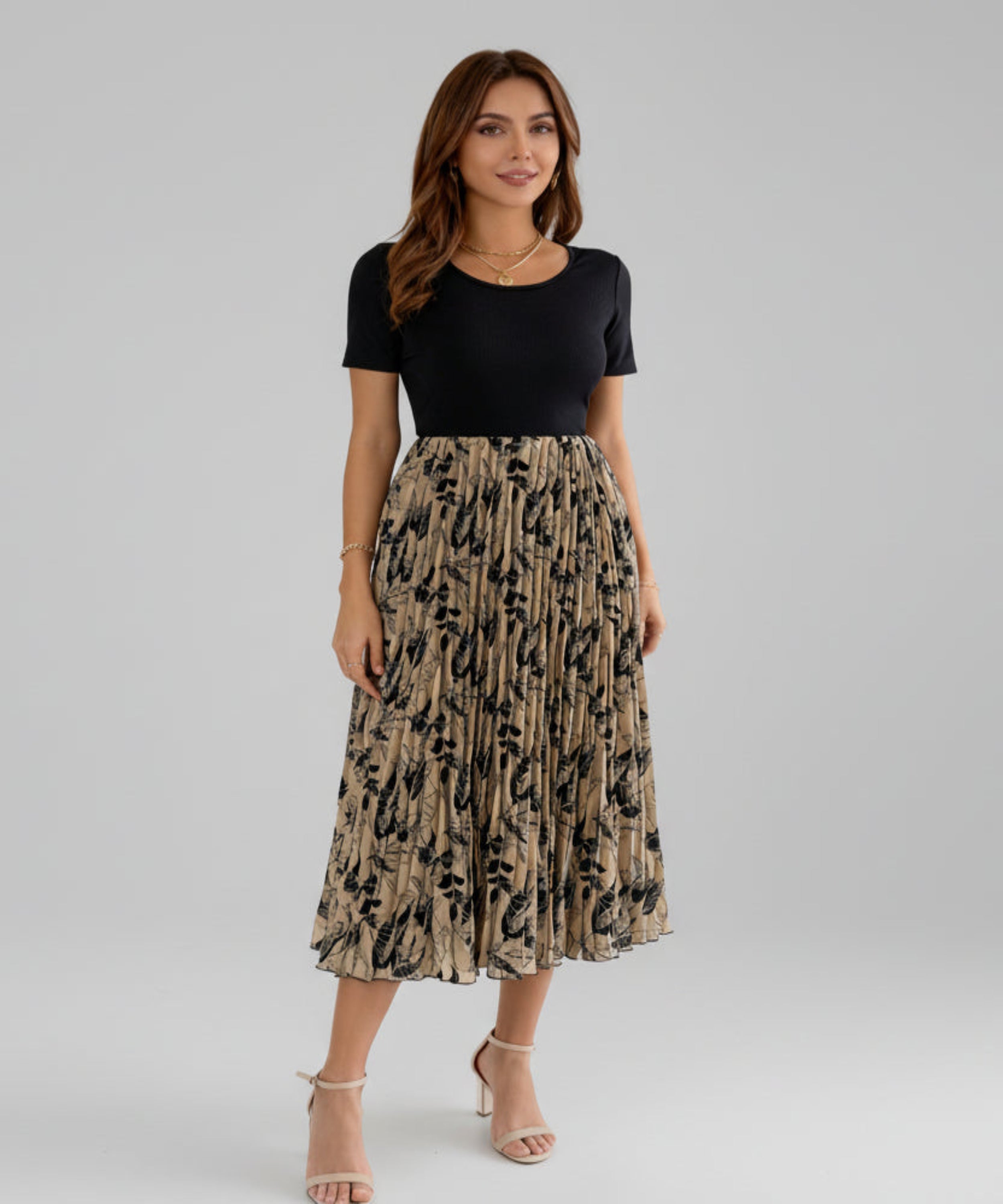 Woman wearing a black top and patterned skirt on a white background