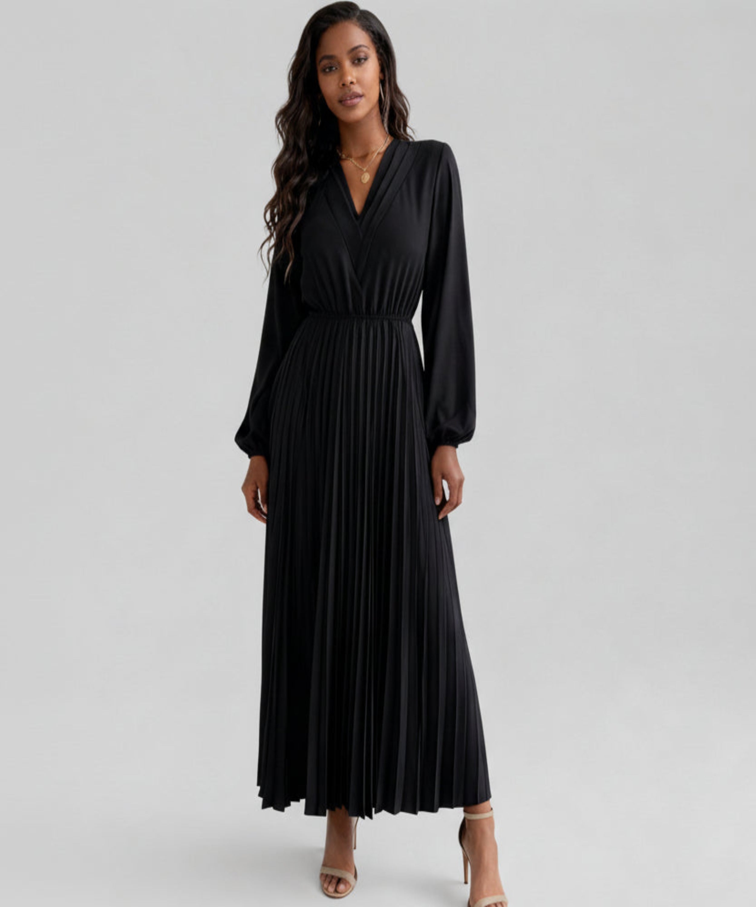 Woman wearing a black long-sleeve dress on a white background