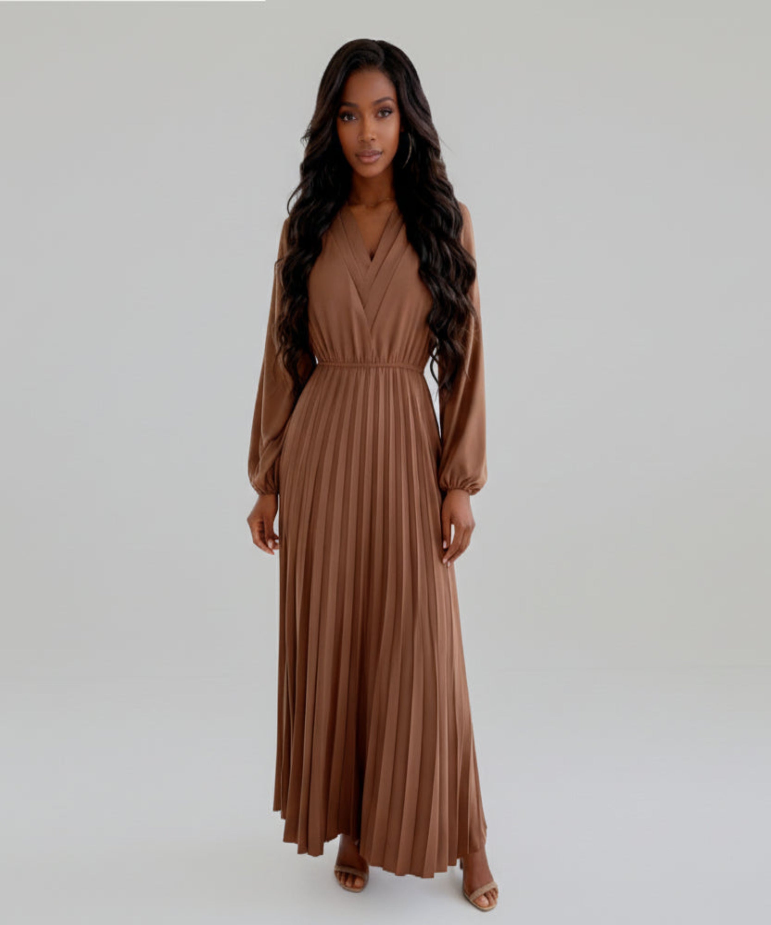Woman wearing a brown long-sleeve dress on a white background
