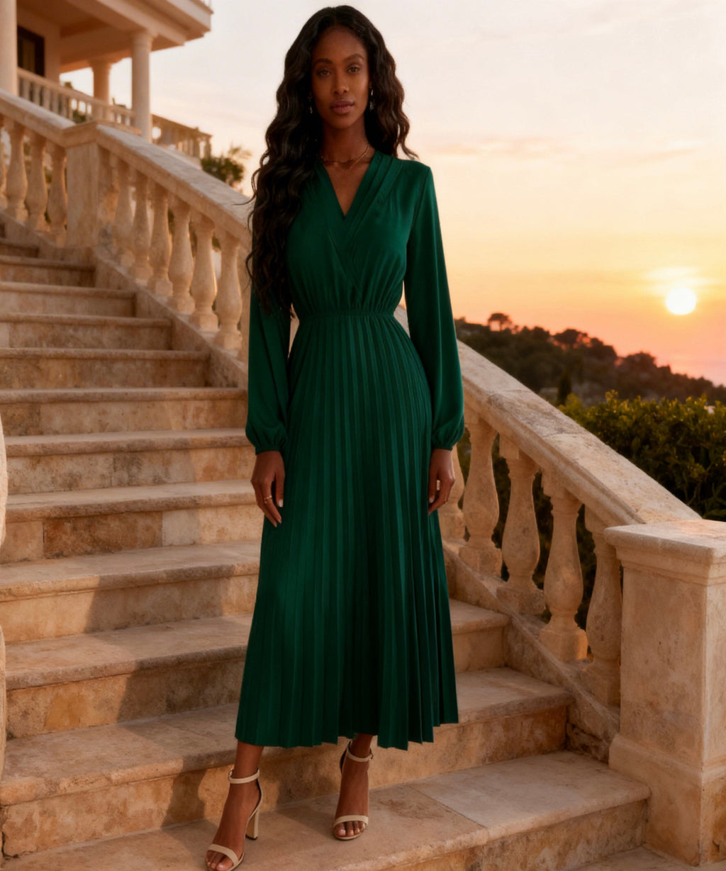Woman in a green dress standing on stone steps with a sunset in the background
