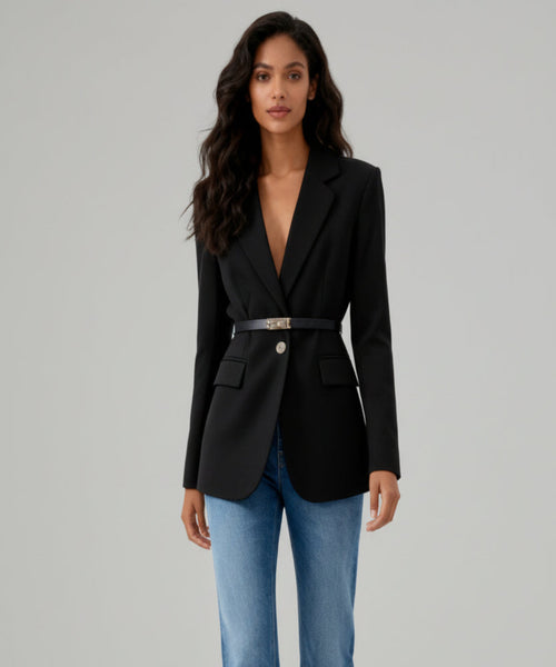 Woman wearing a black blazer and blue jeans on a white background