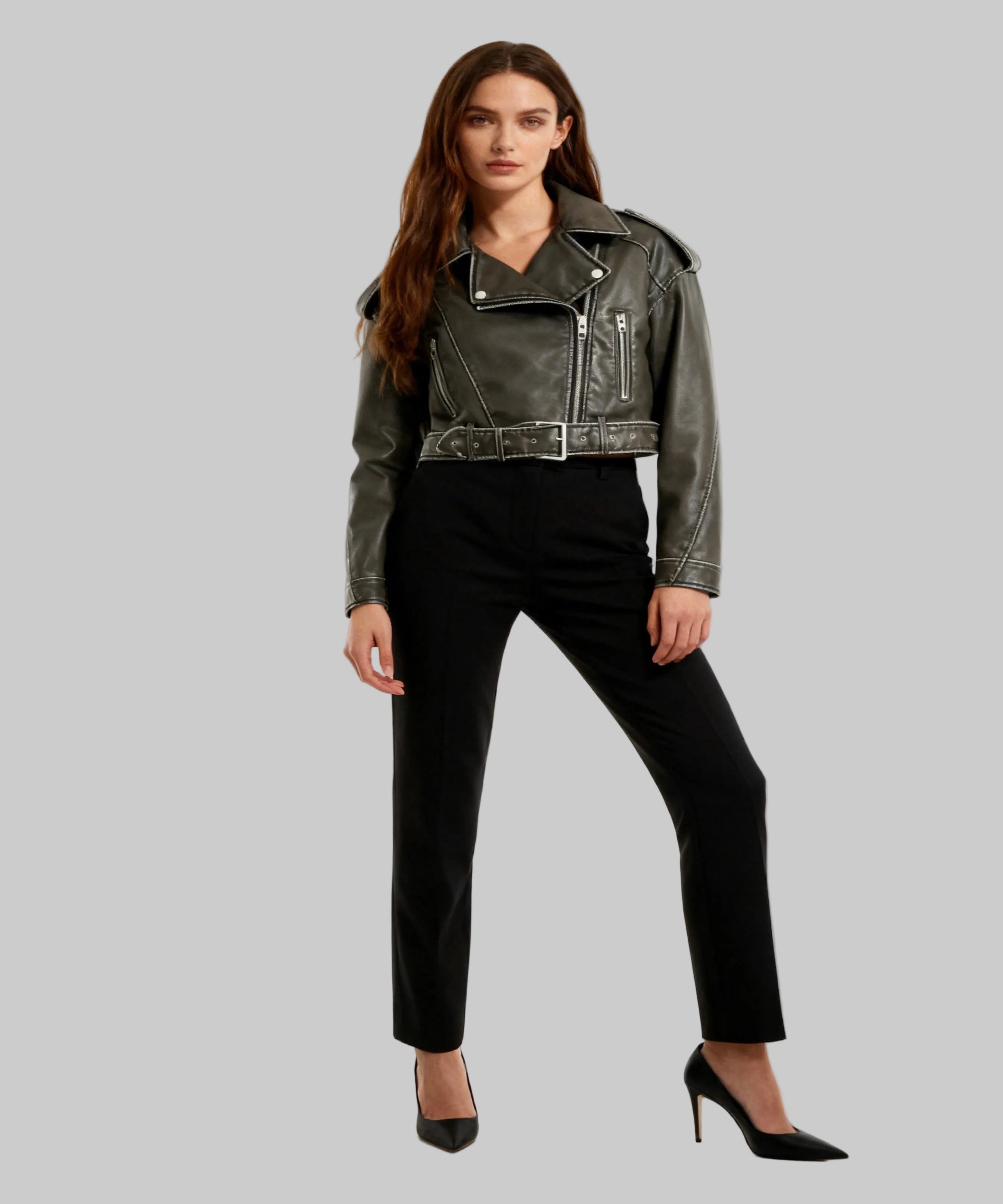Woman wearing a black leather jacket and black pants on a white background