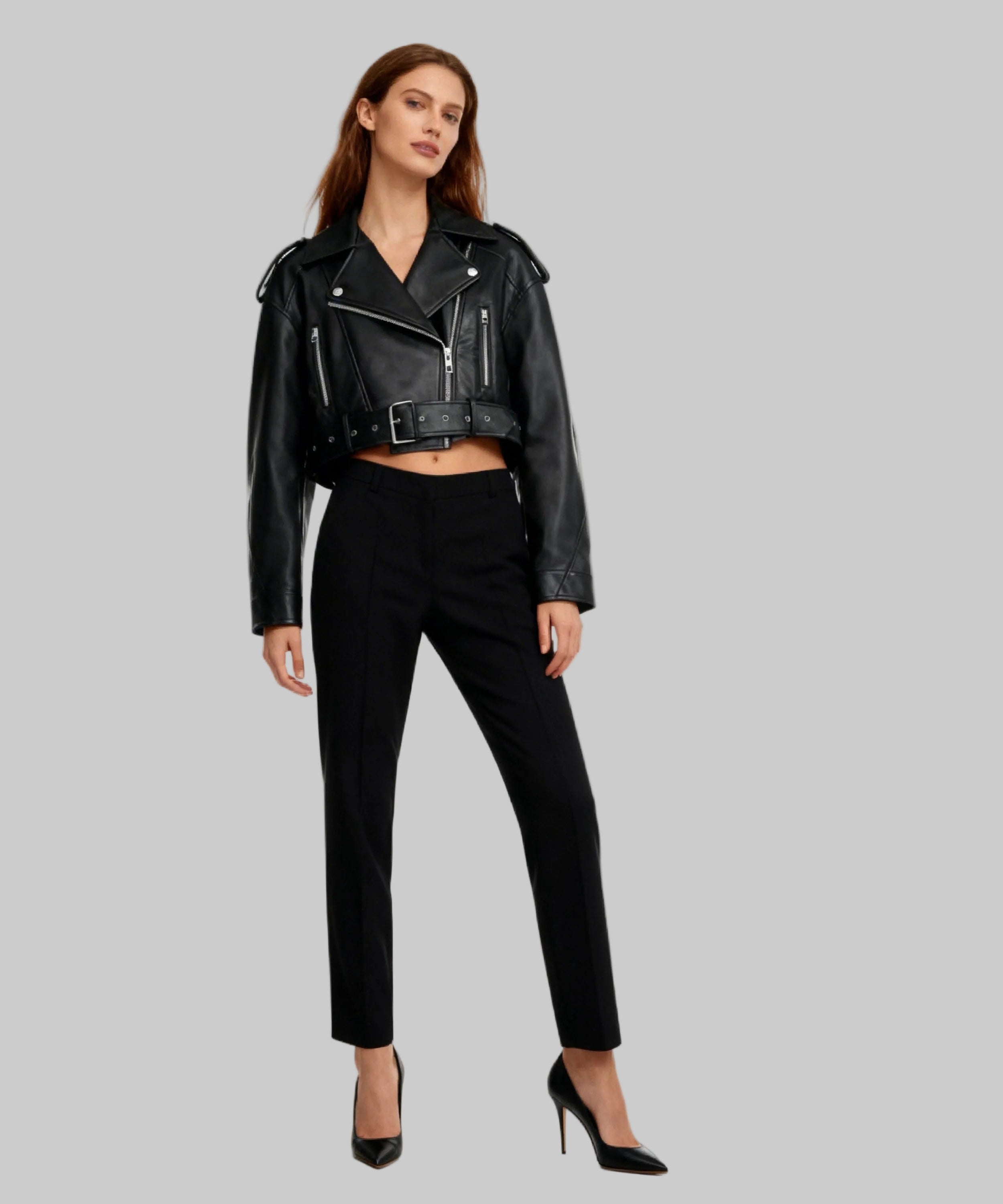 Woman wearing a black leather jacket and pants on a white background