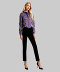Woman wearing a purple denim jacket with floral embroidery on a white background