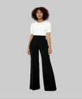 Woman wearing a white top and black wide-leg pants on a white background