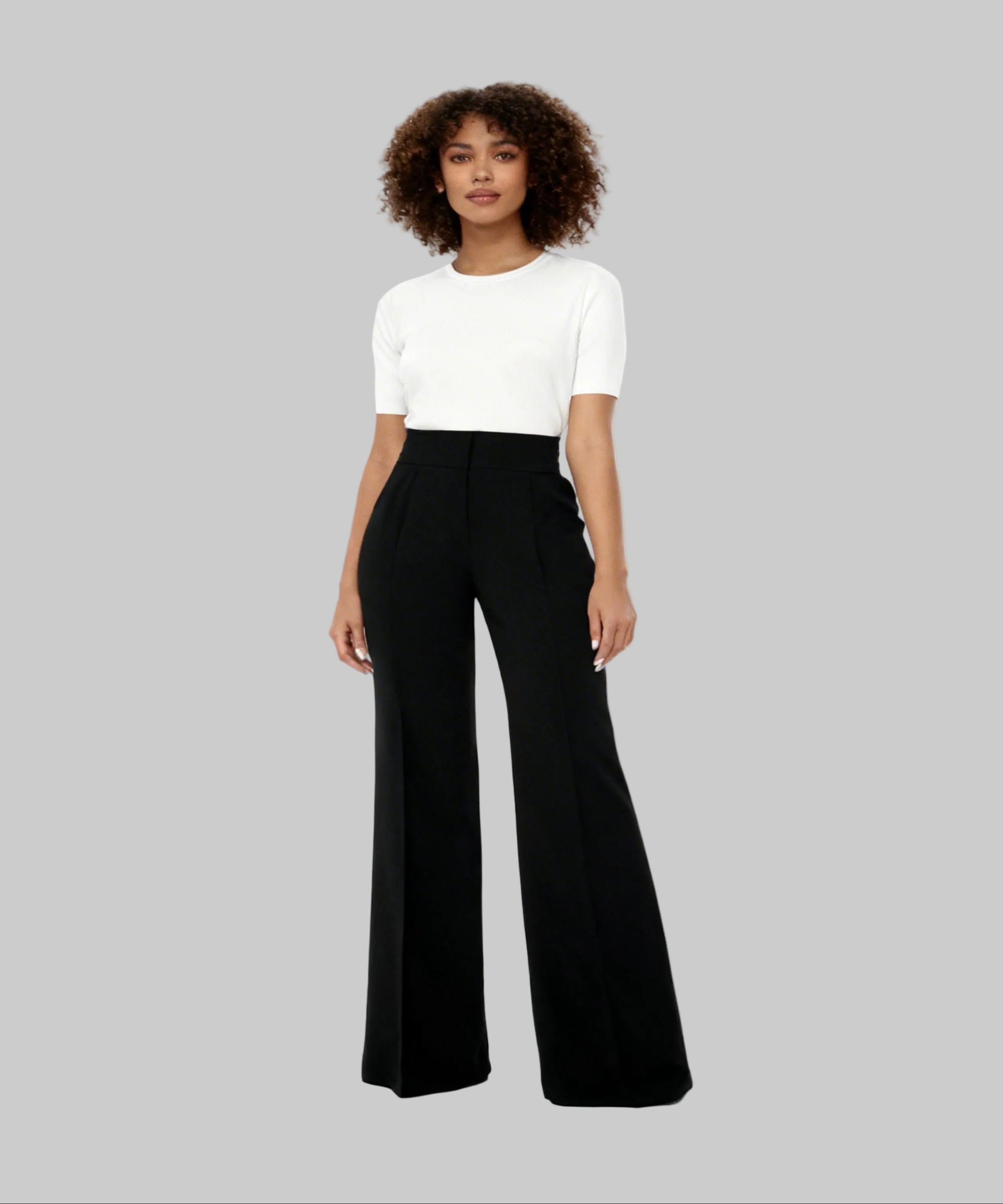 Woman wearing a white top and black wide-leg pants on a white background