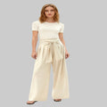Woman wearing a white top and beige wide-leg pants on a white background