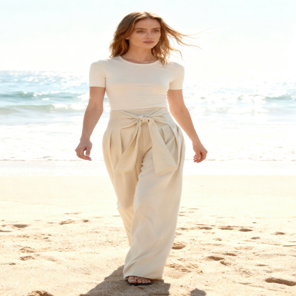 Woman in a white outfit walking on a beach