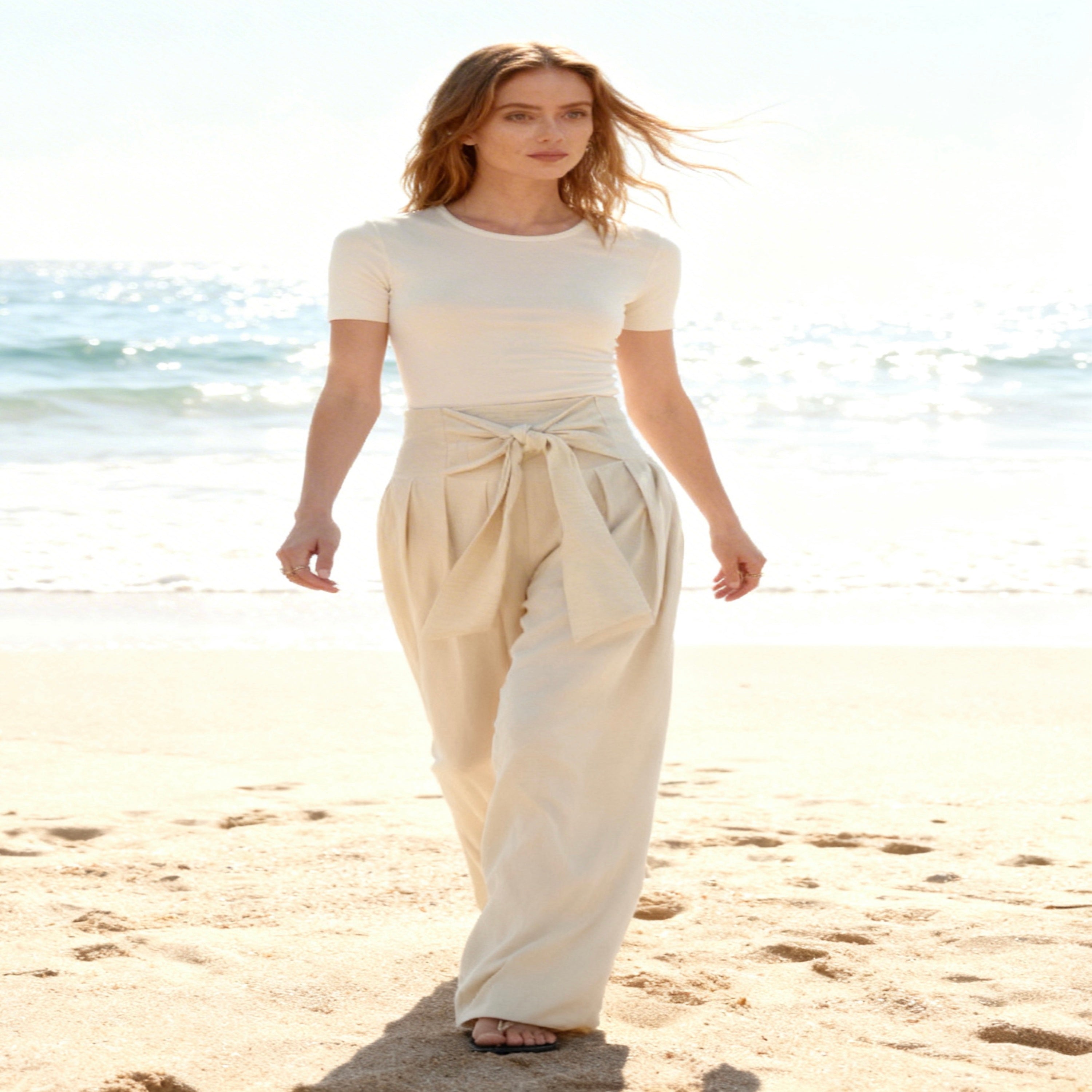 Woman in a white outfit walking on a beach