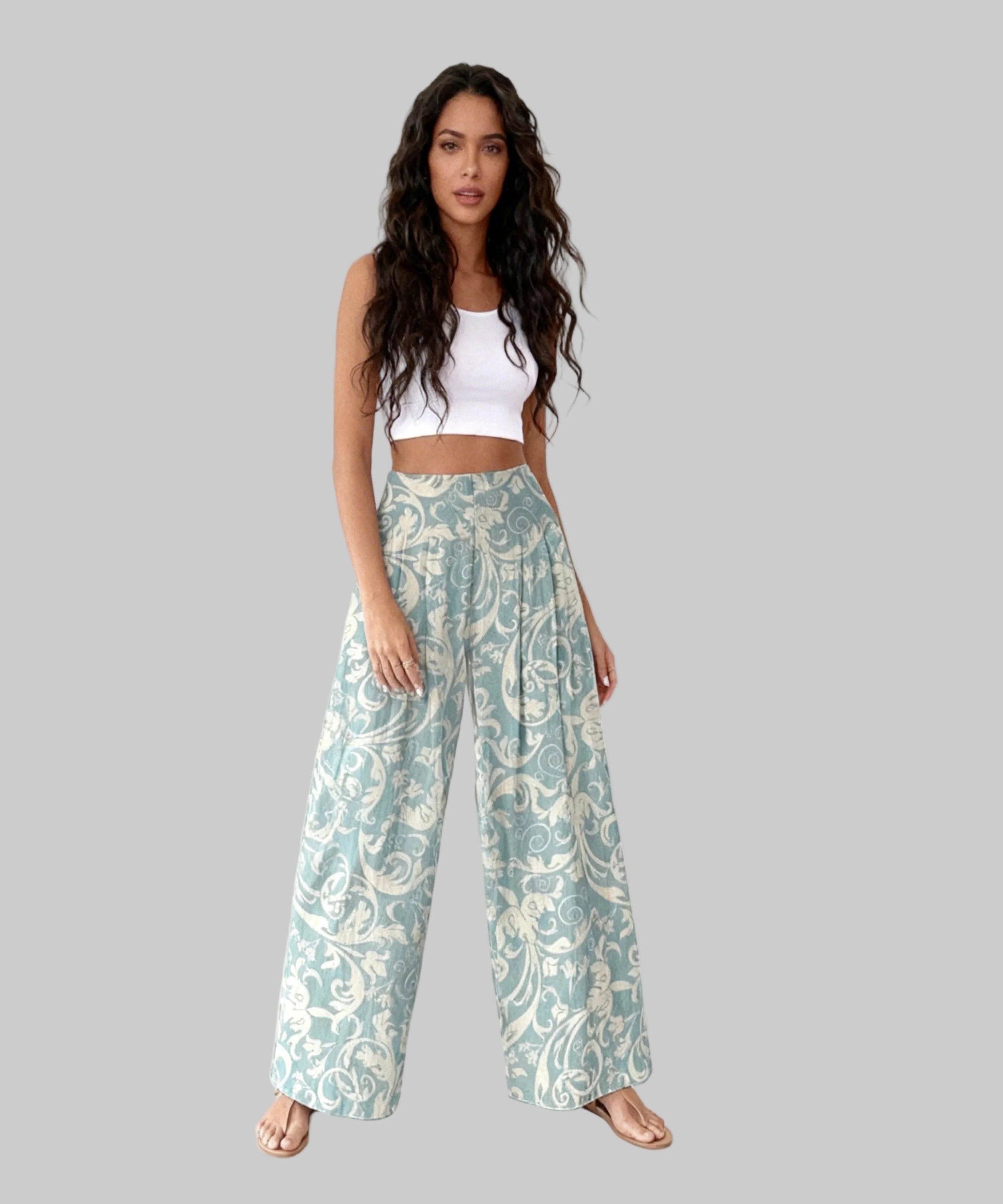 Woman wearing a white top and patterned pants on a white background