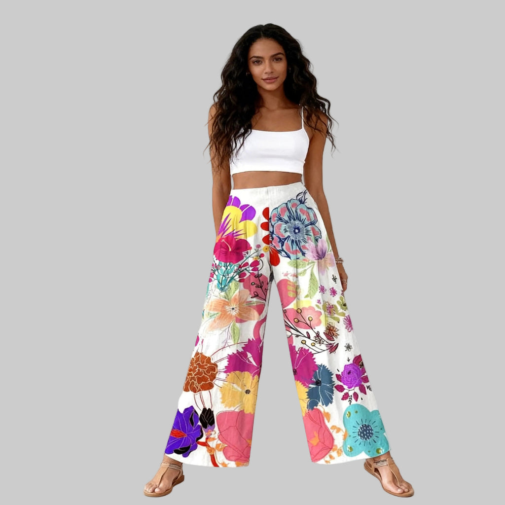 Woman wearing a white top and colorful floral pants on a white background