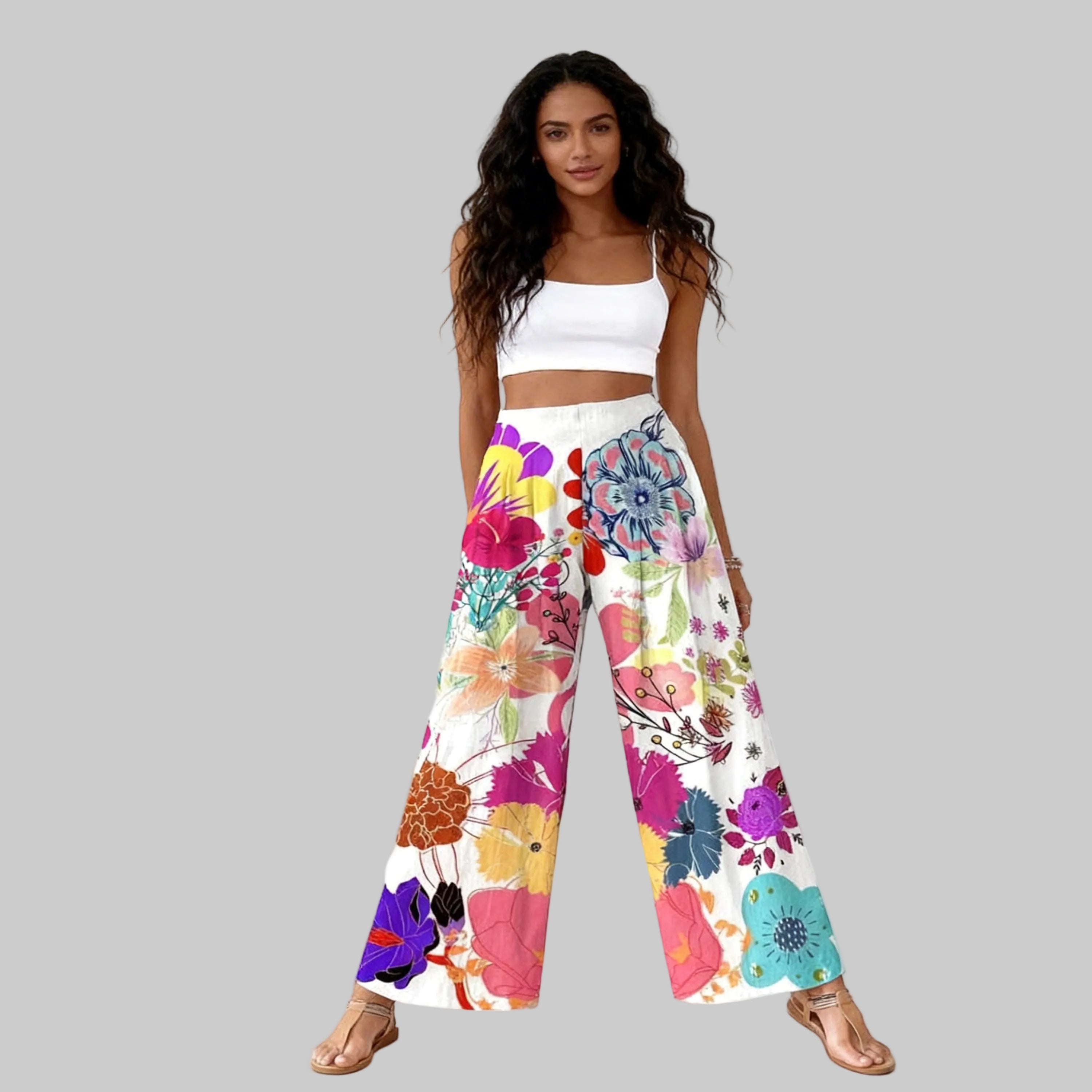 Woman wearing a white top and colorful floral pants on a white background