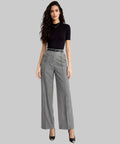 Woman wearing a black top and gray high-waisted pants on a white background