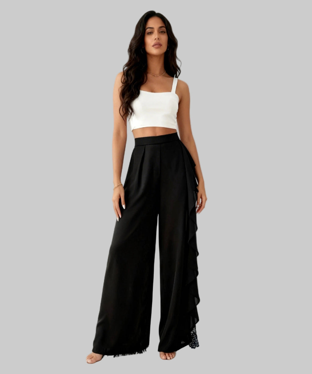 Woman wearing a white top and black wide-leg pants on a white background