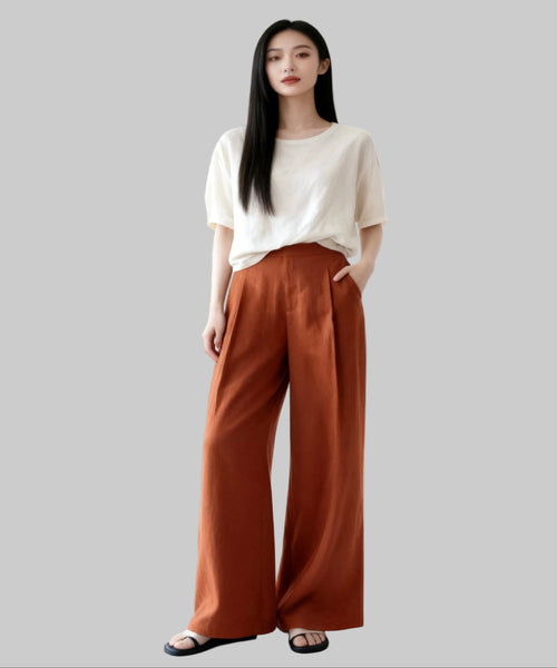 Woman wearing a white top and brown pants on a white background