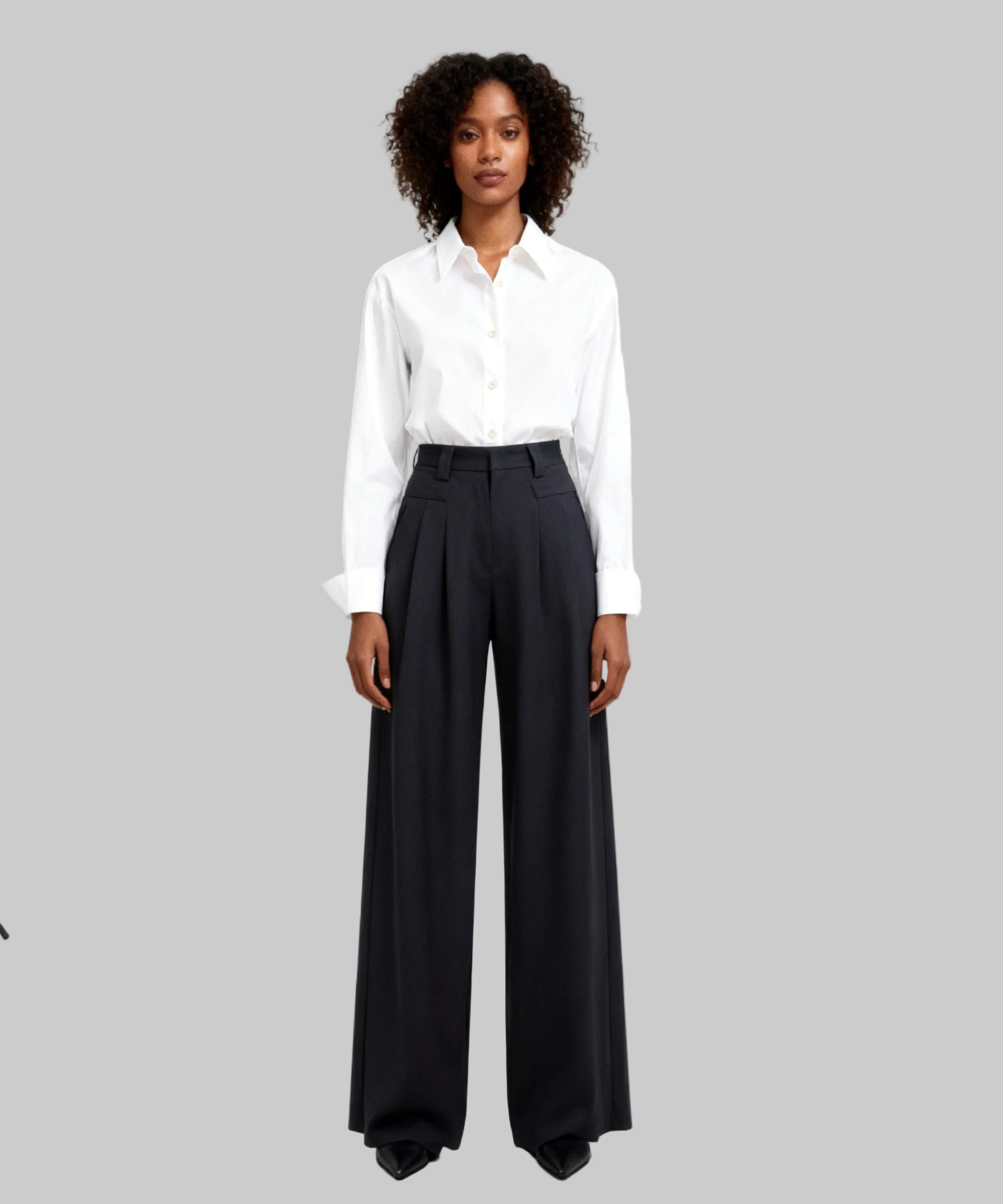 Woman wearing a white shirt and black wide-leg pants on a white background