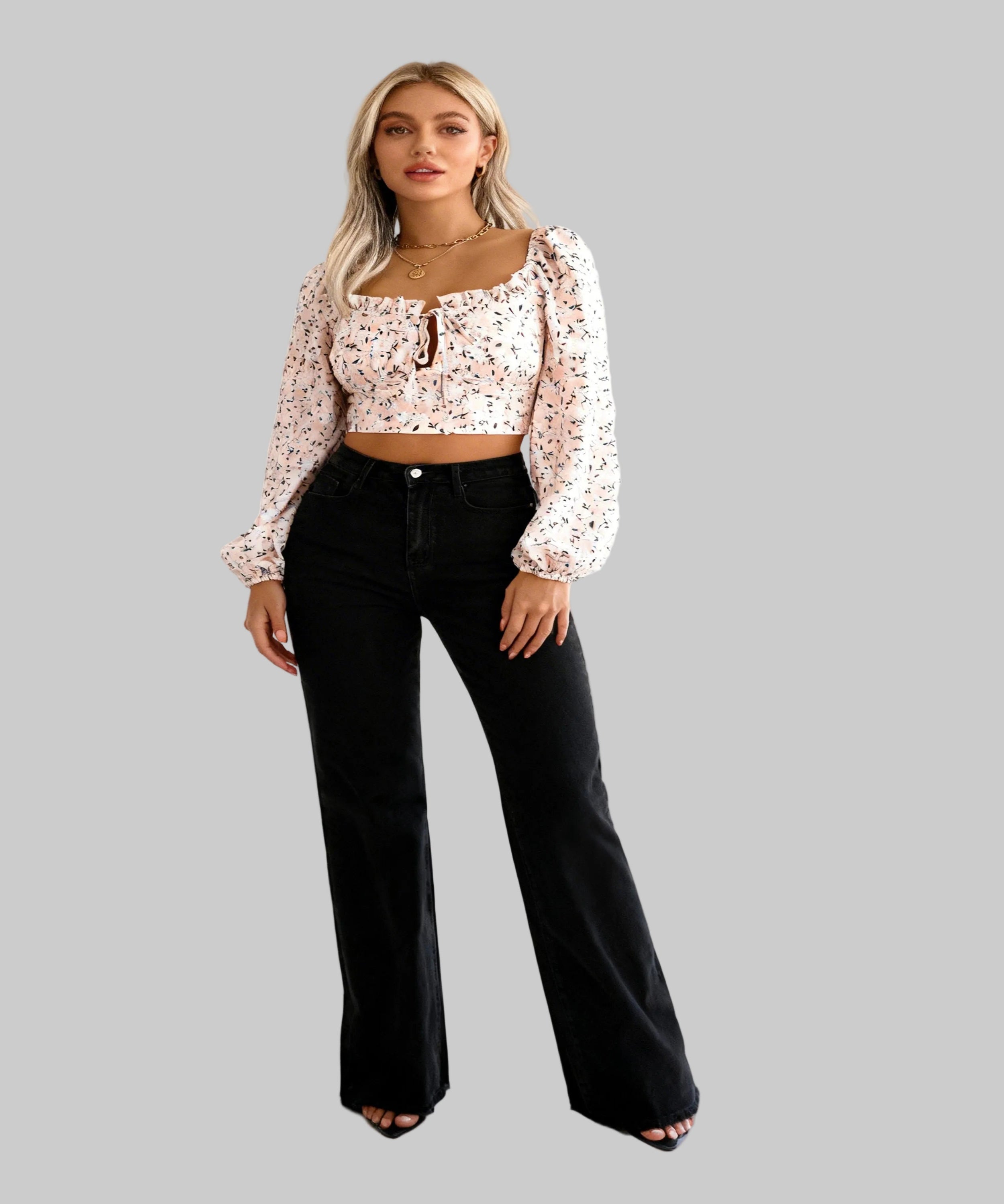 Woman wearing a floral blouse and black pants on a white background