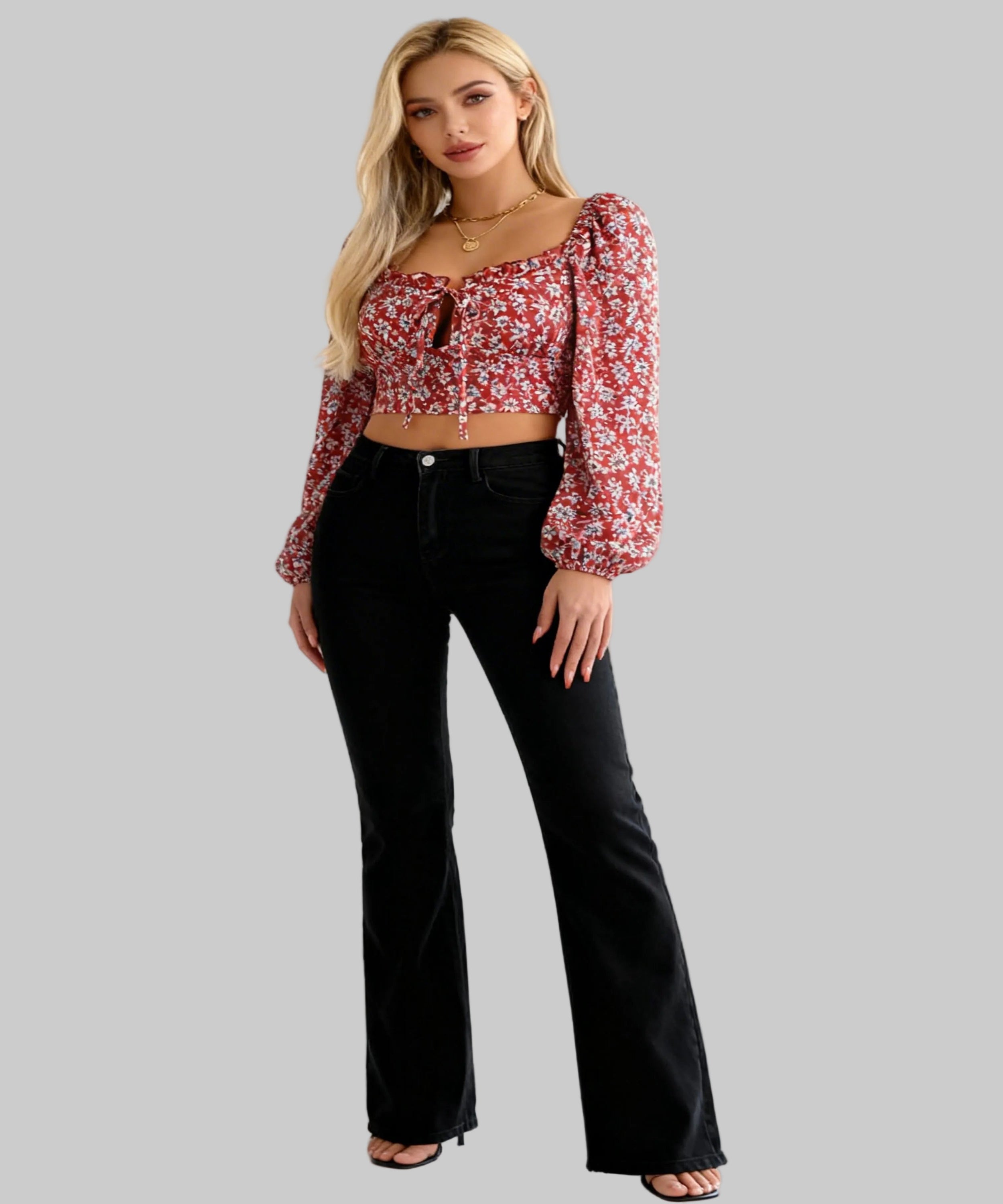 Woman wearing a floral blouse and black pants on a white background