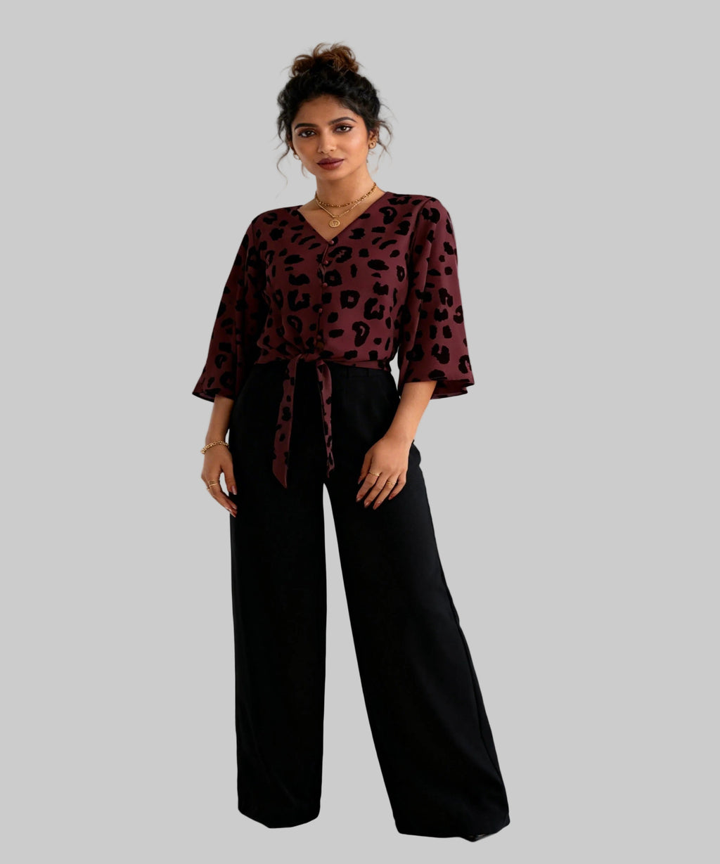 Woman wearing a leopard print top and black pants on a white background