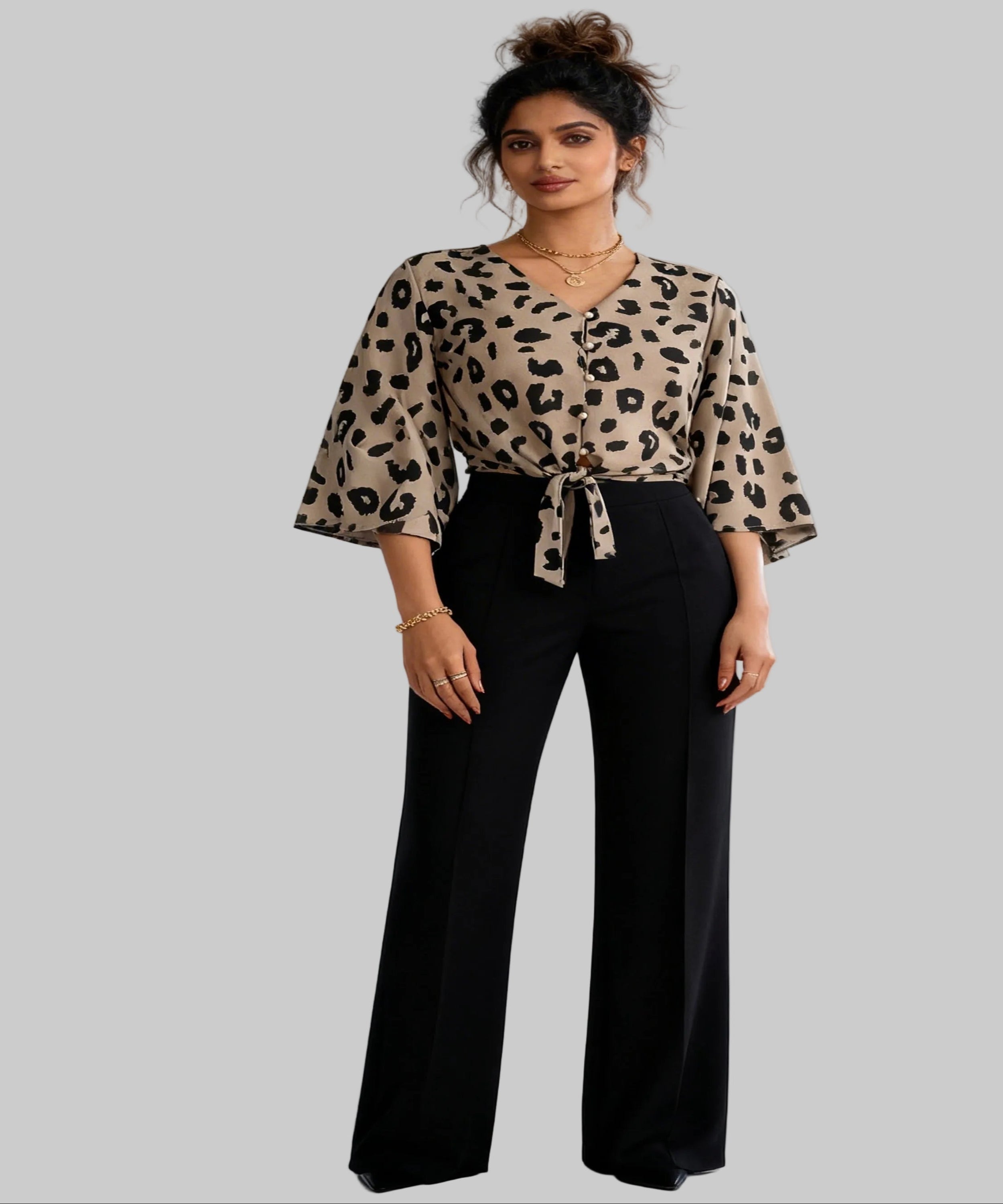 Woman wearing a leopard print top and black pants on a white background