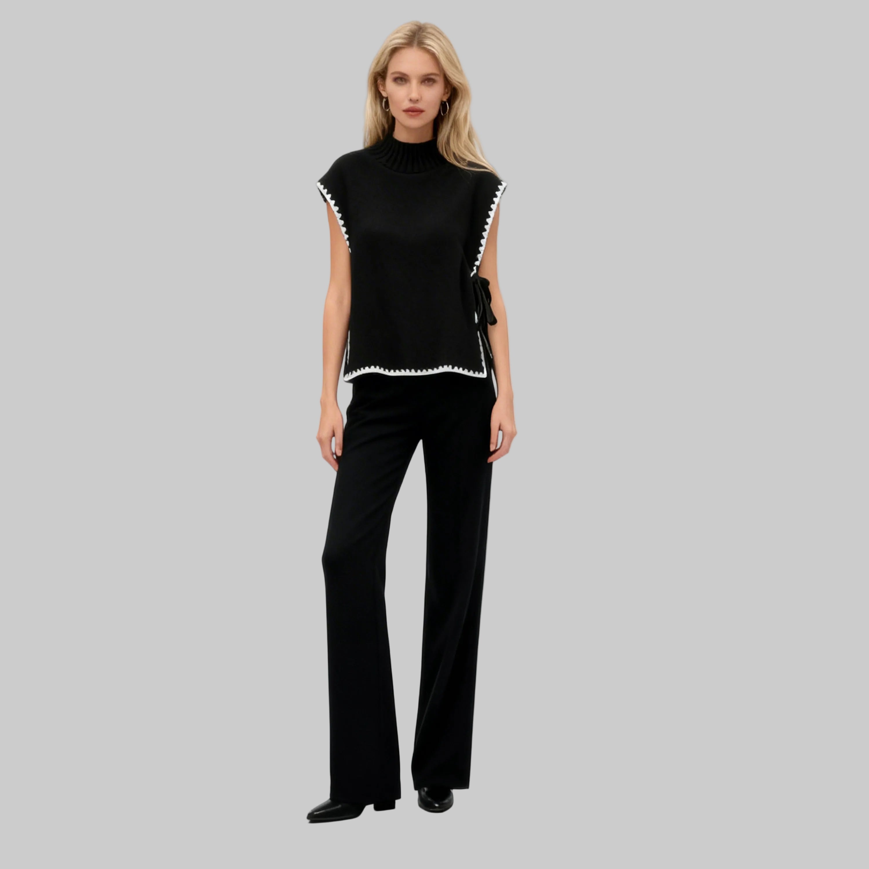 Woman wearing a black outfit with white trim on a white background