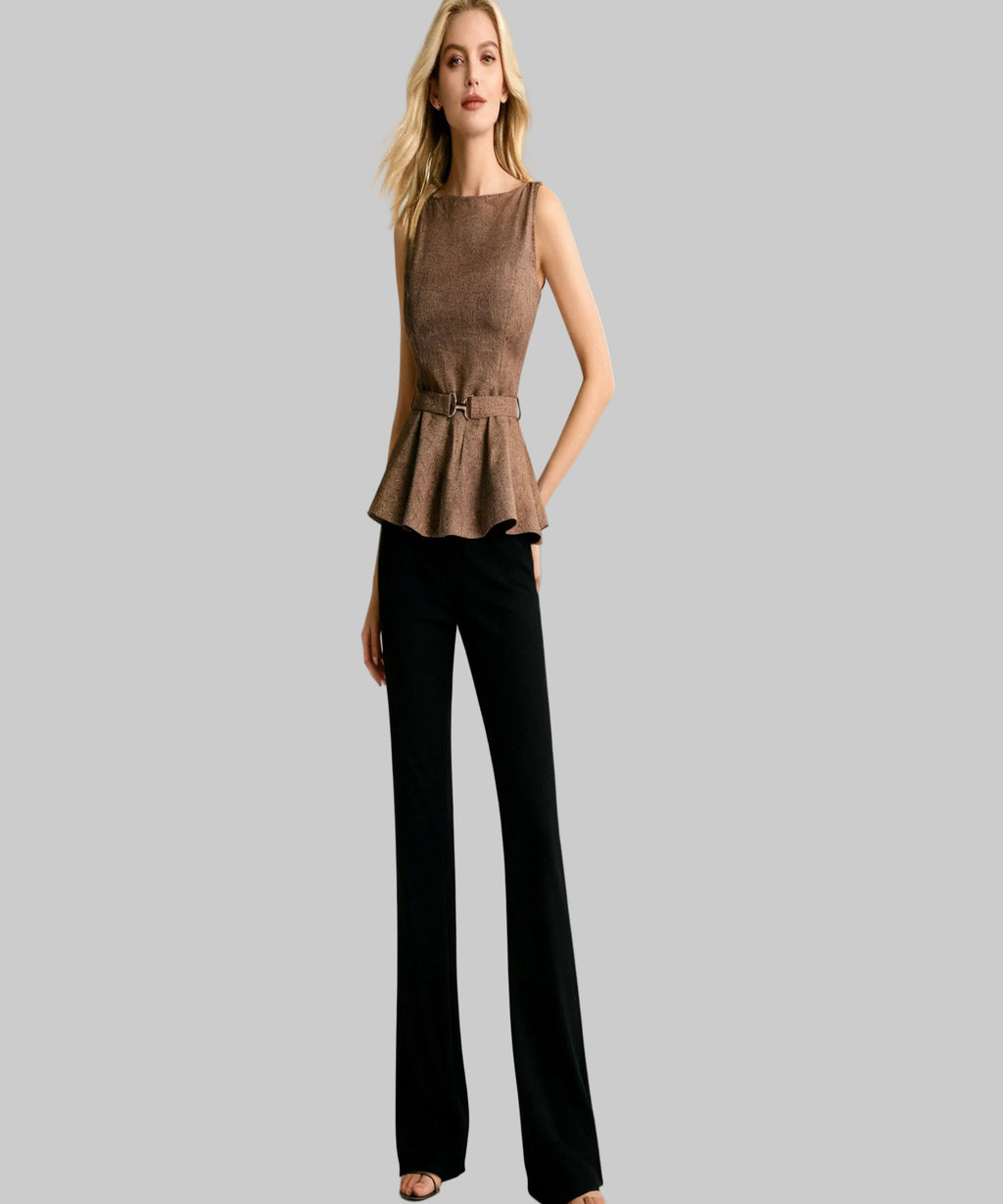 Woman wearing a brown peplum top and black pants on a white background