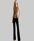 Woman wearing a brown peplum top and black pants on a white background