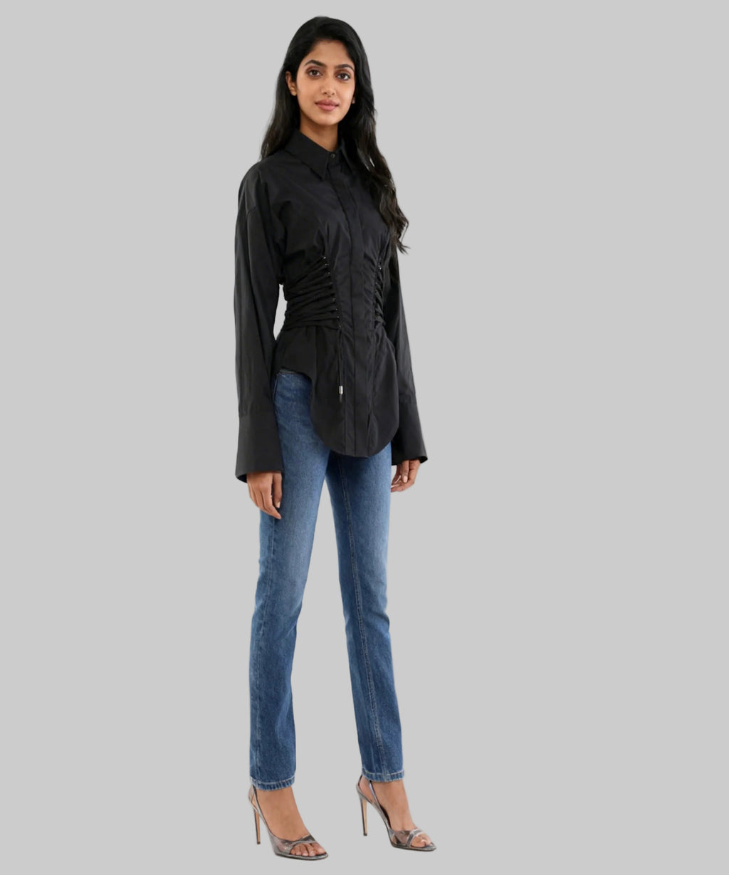 Woman wearing a black jacket and blue jeans on a white background