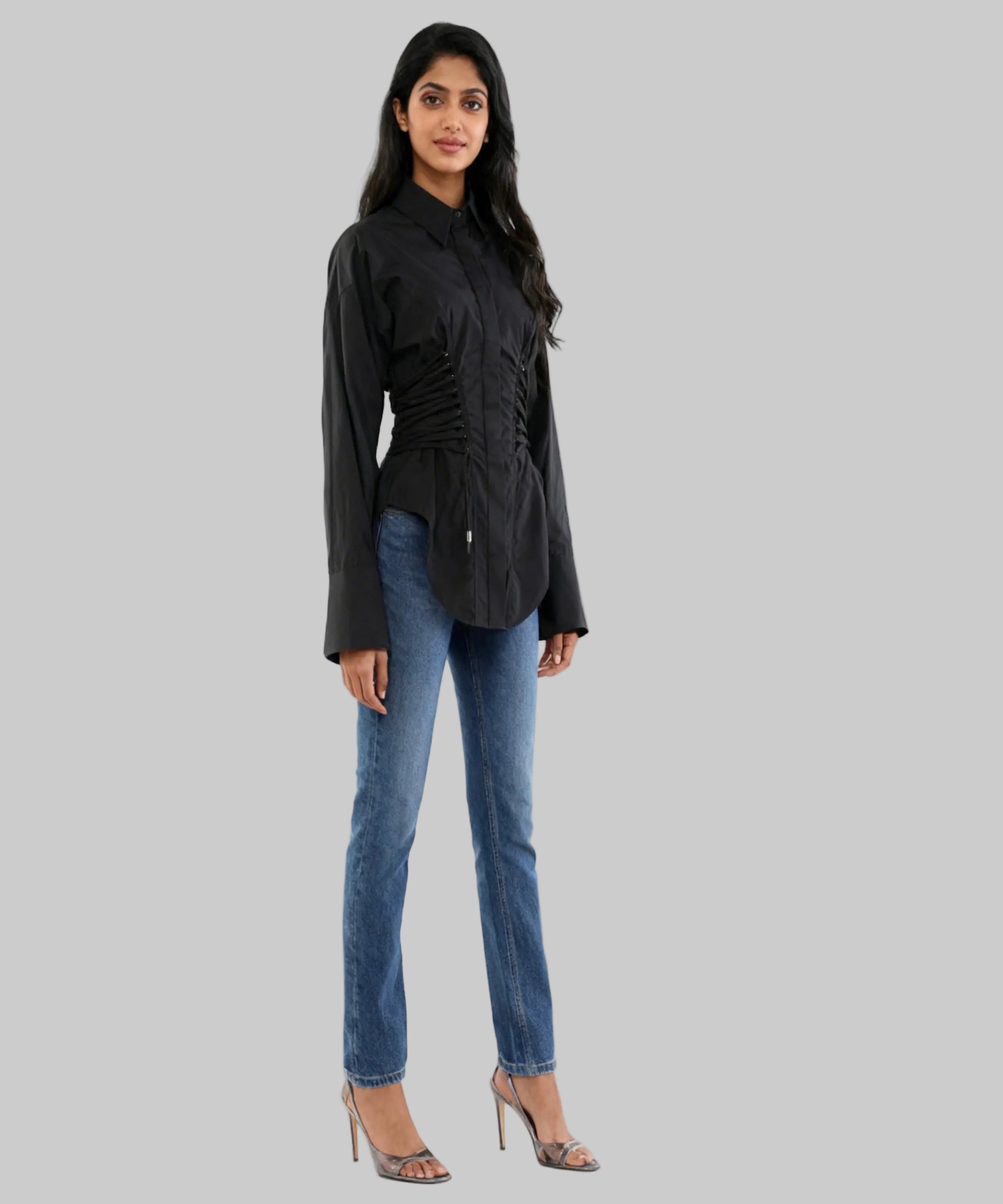 Woman wearing a black jacket and blue jeans on a white background