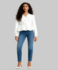 Woman wearing a white blouse and blue jeans on a white background