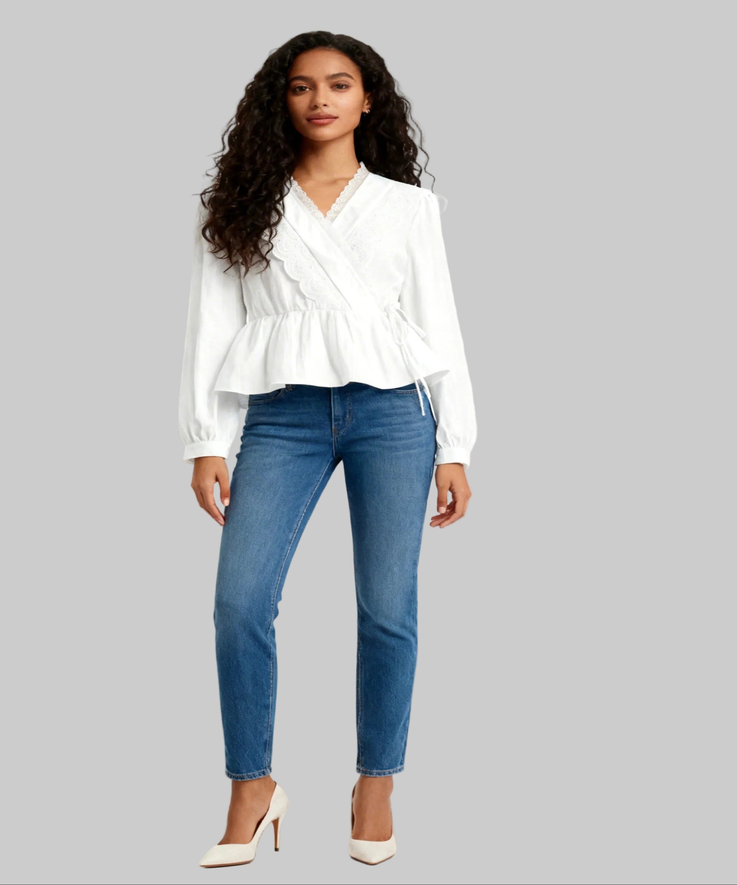 Woman wearing a white blouse and blue jeans on a white background