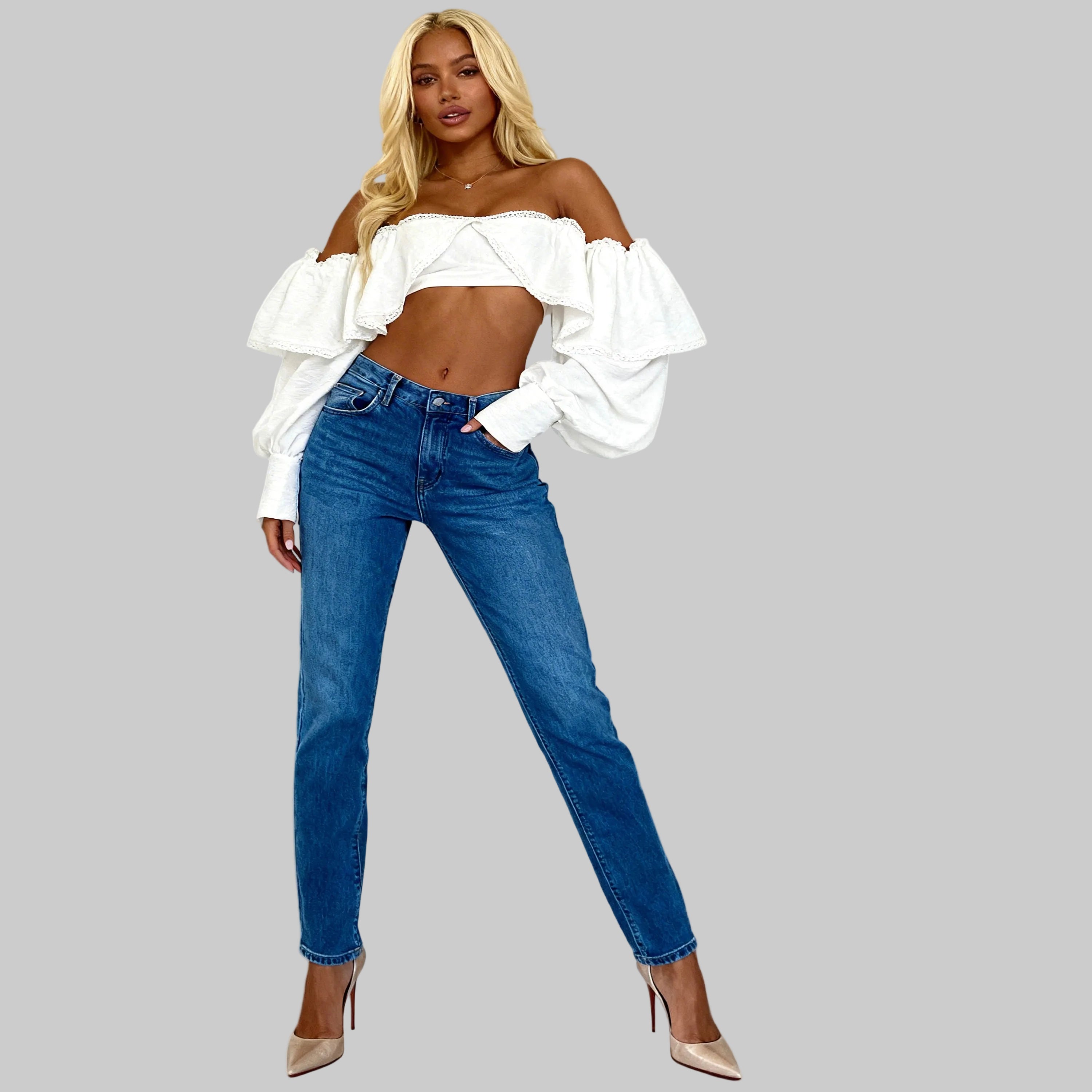 Woman wearing a white off-shoulder top and blue jeans on a white background