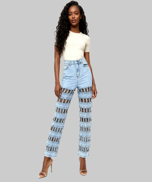 Woman wearing light blue jeans with a patterned design on a white background