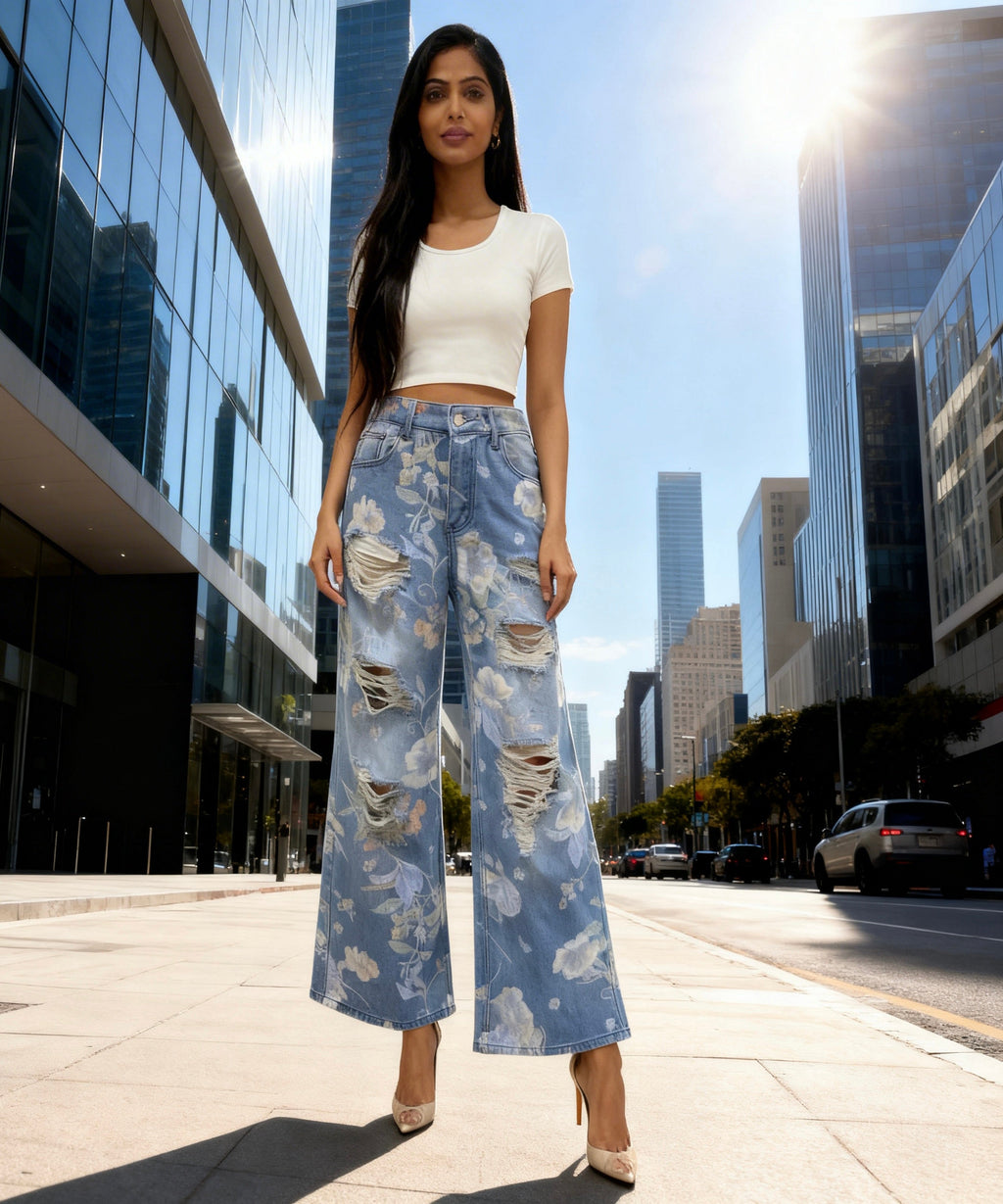 Woman in floral jeans and white top standing on a city street with modern buildings in the background