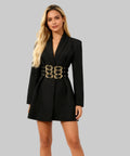 Woman wearing a black blazer dress with gold belt on a white background