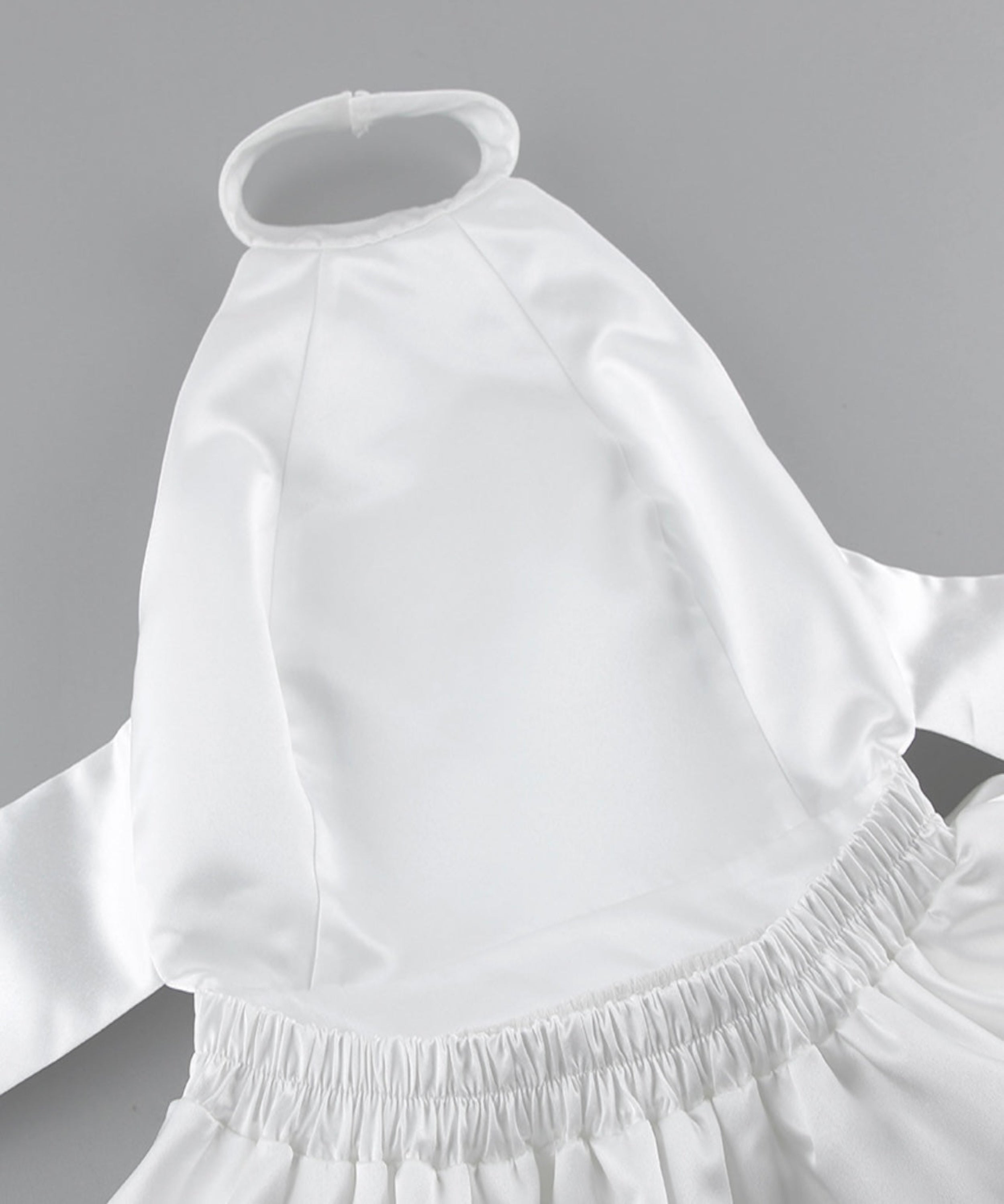 White dress with a fitted bodice and flowing skirt on a gray background
