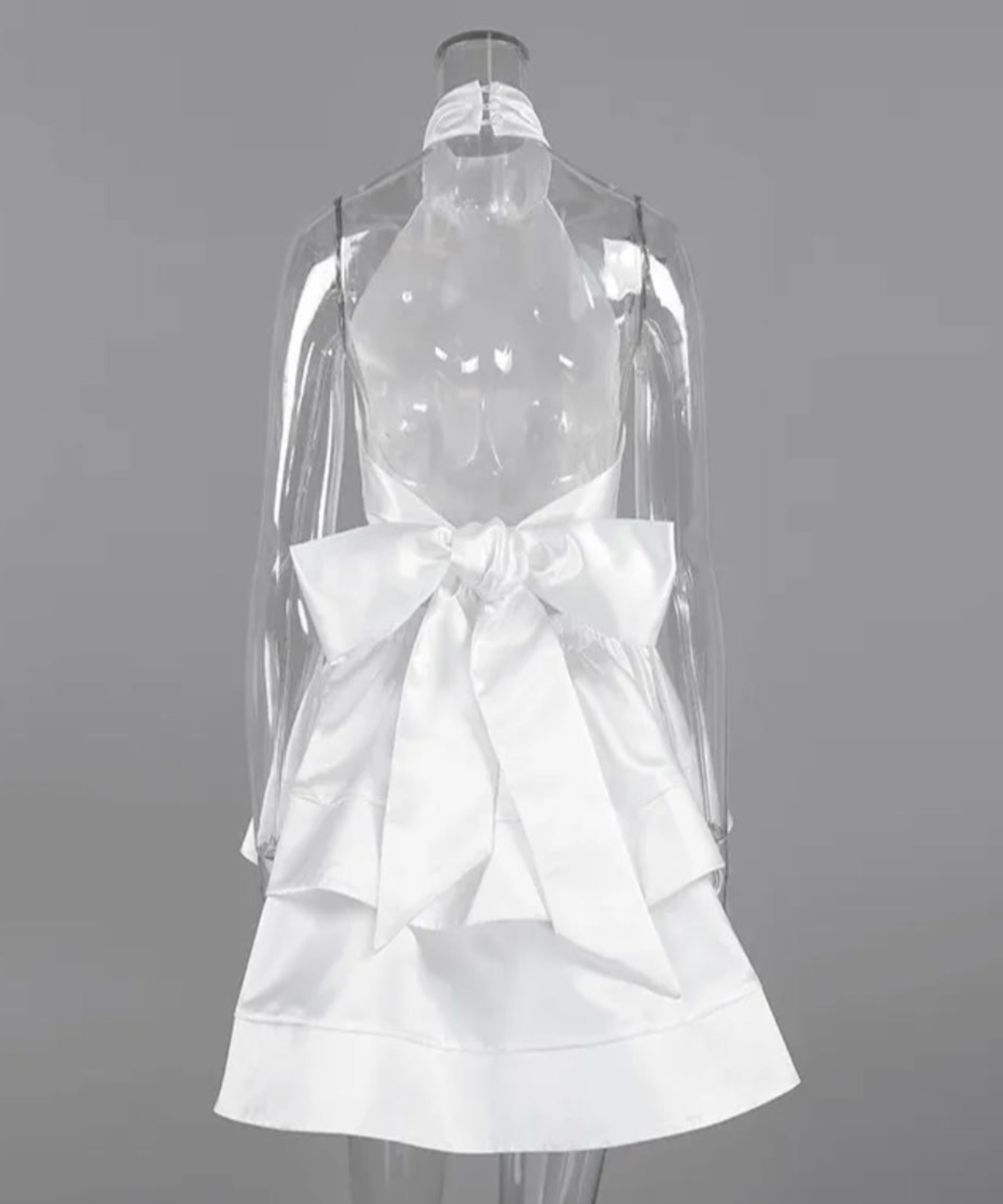 White dress with a large bow on a mannequin against a gray background