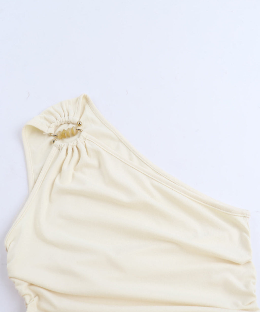 Beige one-shoulder top on a light gray background